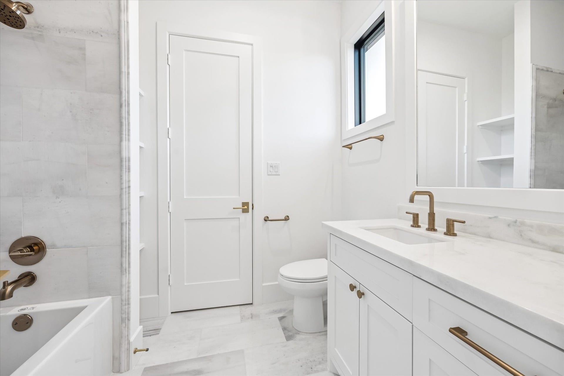 Natural light, classic stone finishes, and a tub and shower combination create a clean, functional layout suited for daily use. Ample vanity storage and built in shelving support organization while maintaining a bright, timeless feel.**Previous build by Arch Angelo**