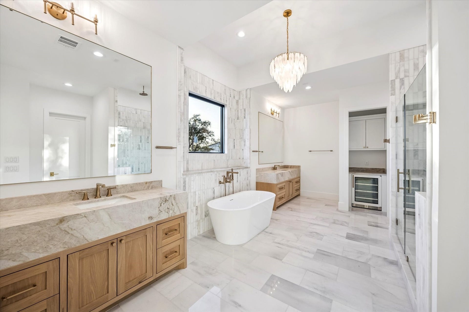Primary bath feels intentionally spa like with a freestanding soaking tub centered beneath a window and a separate walk in shower for everyday ease. Dual vanities, generous circulation space, and layered lighting elevate both function and comfort.**Previous build by Arch Angelo**