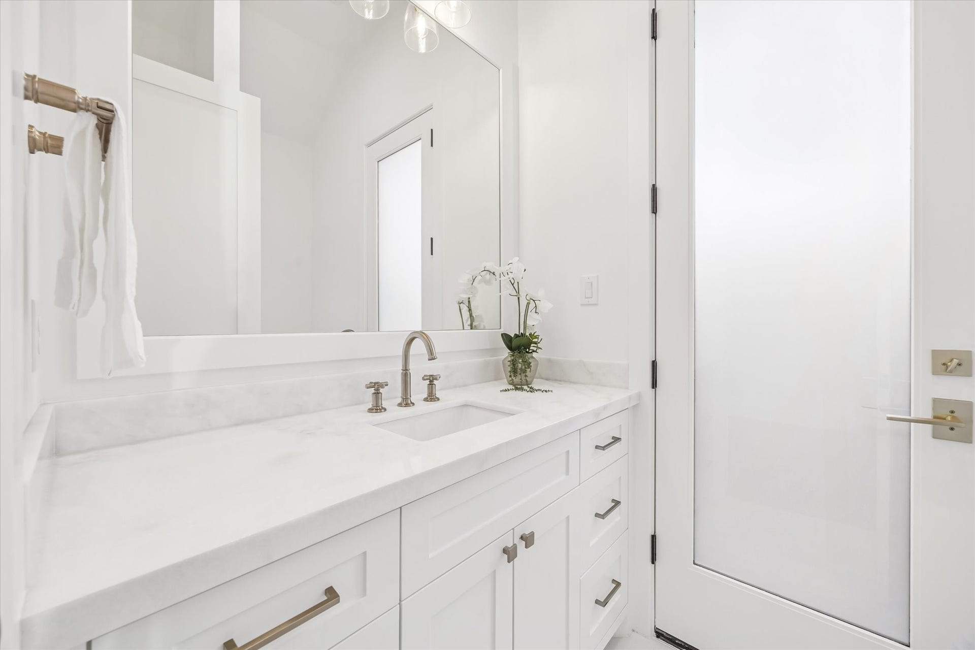 Thoughtfully designed powder bath features clean lines, stone countertops, and generous vanity storage. Positioned for guests, it offers a polished touch without interrupting the main living areas. **Previous build by Arch Angelo**