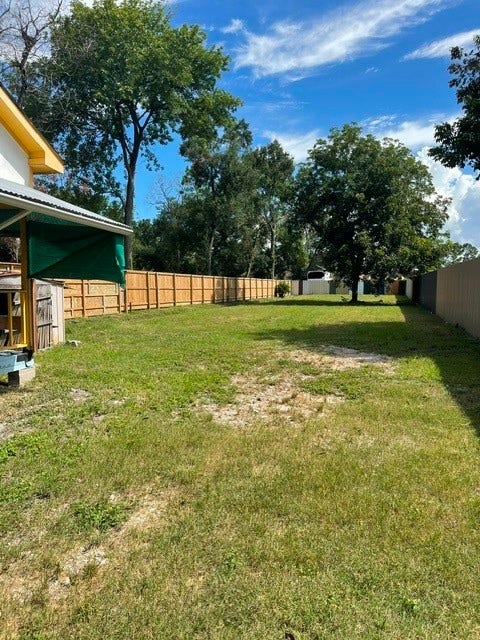 408 B Vista Road, Pasadena, TX 77504 Expansive backyard with lush greenery, mature trees, and privacy fencing, perfect for outdoor activities and relaxation.
