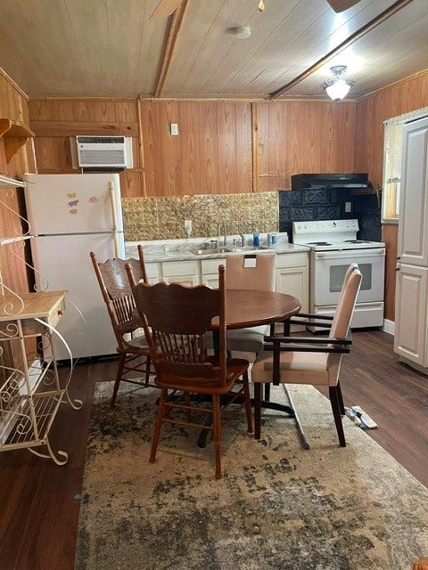 408 B Vista Road, Pasadena, TX 77504 Cozy kitchen with warm wood paneling features a round dining table, ample cabinet space, and essential appliances including a stove and refrigerator.