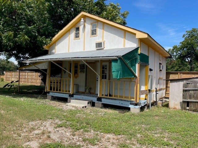 408 B Vista Road, Pasadena, TX 77504 Charming rustic tiny home with a covered porch, nestled in a spacious yard, perfect for outdoor enjoyment and relaxation.