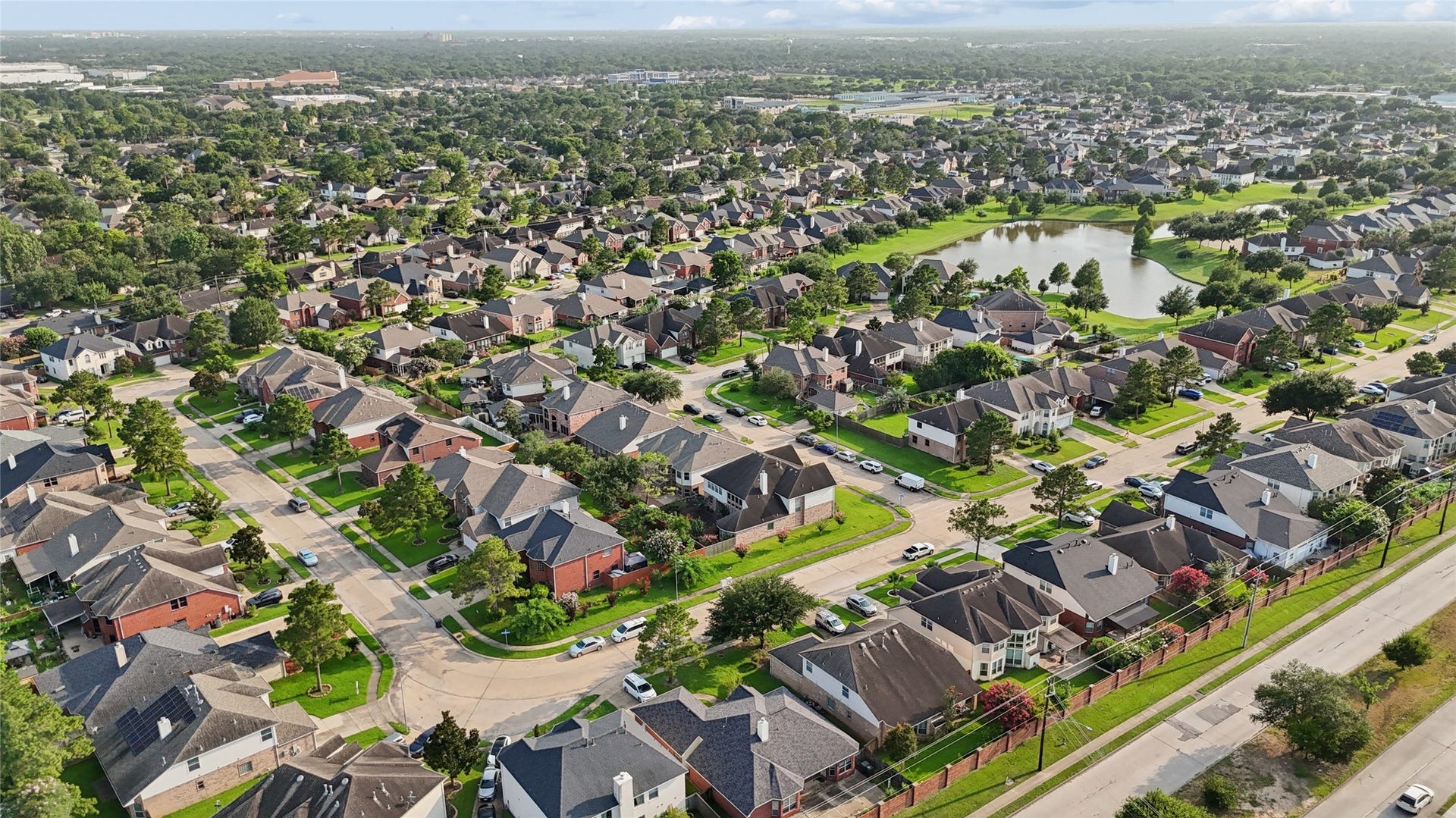 2614 Sunset Lake Drive, Sugar Land, TX 77478 This aerial photo showcases a sprawling suburban neighborhood with well-maintained homes, tree-lined streets, and a nearby pond. The area appears peaceful and family-friendly, with convenient access to amenities and green spaces.