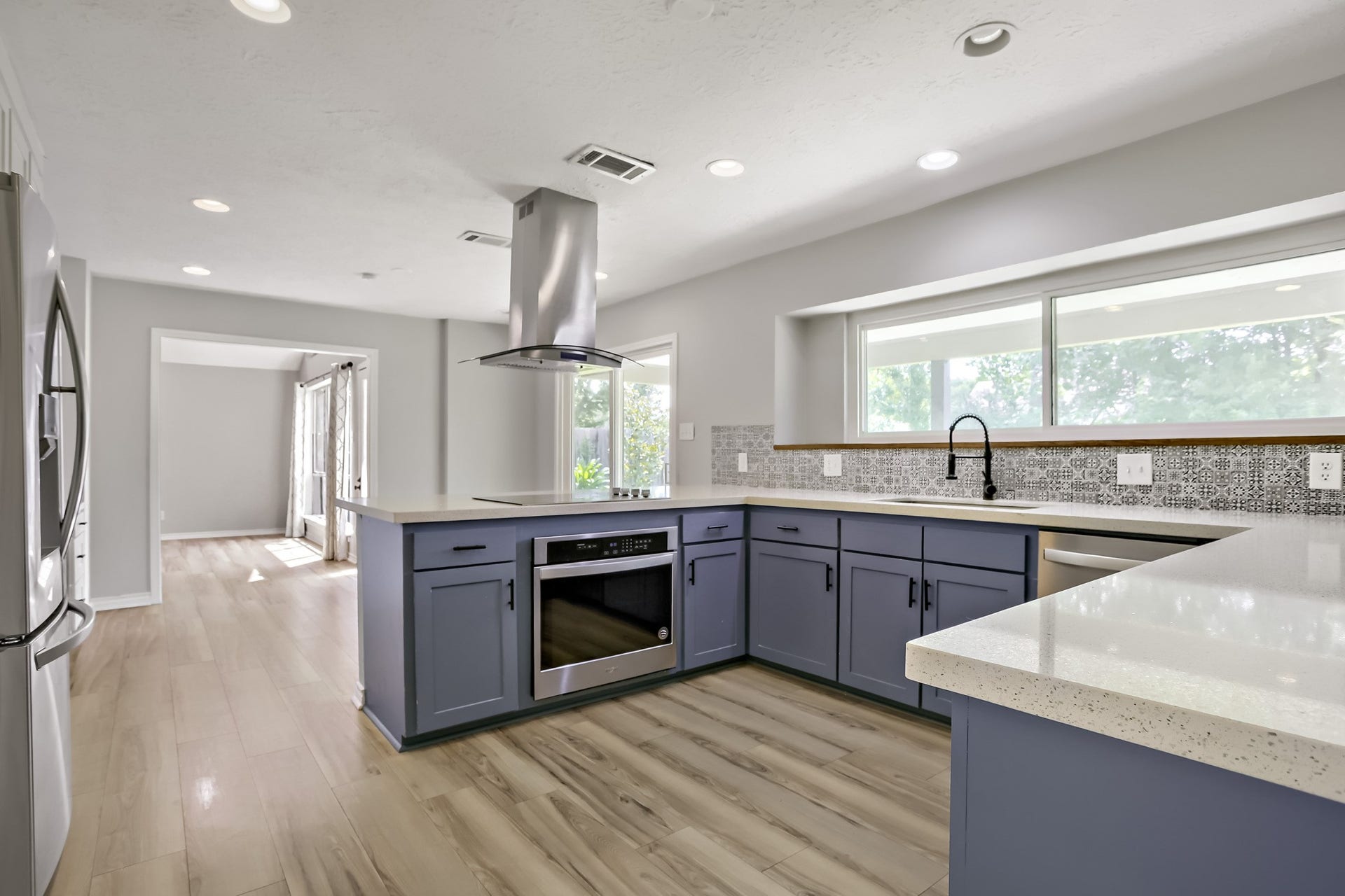 16505 Cornwall Street, Jersey Village, TX 77040 Here's a modern kitchen seamlessly connecting to the den and dining area, perfect for entertaining.