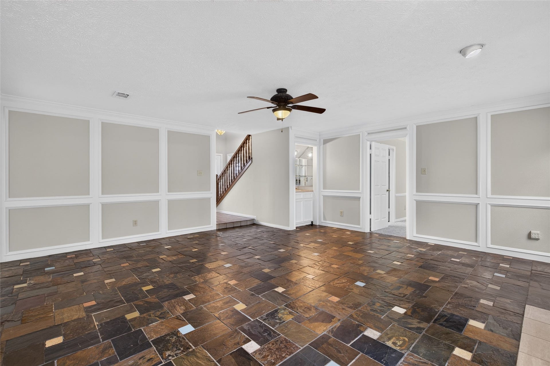 Generous floor space, architectural wall detailing, and easy access to the staircase and adjoining rooms create a functional layout designed to accommodate everyday living.