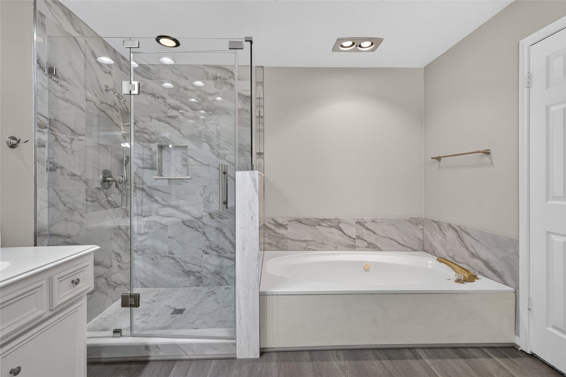 The glass-enclosed shower, marble tile, and soaking tub create a relaxing space where buyers can imagine starting the morning refreshed or unwinding at the end of the day.