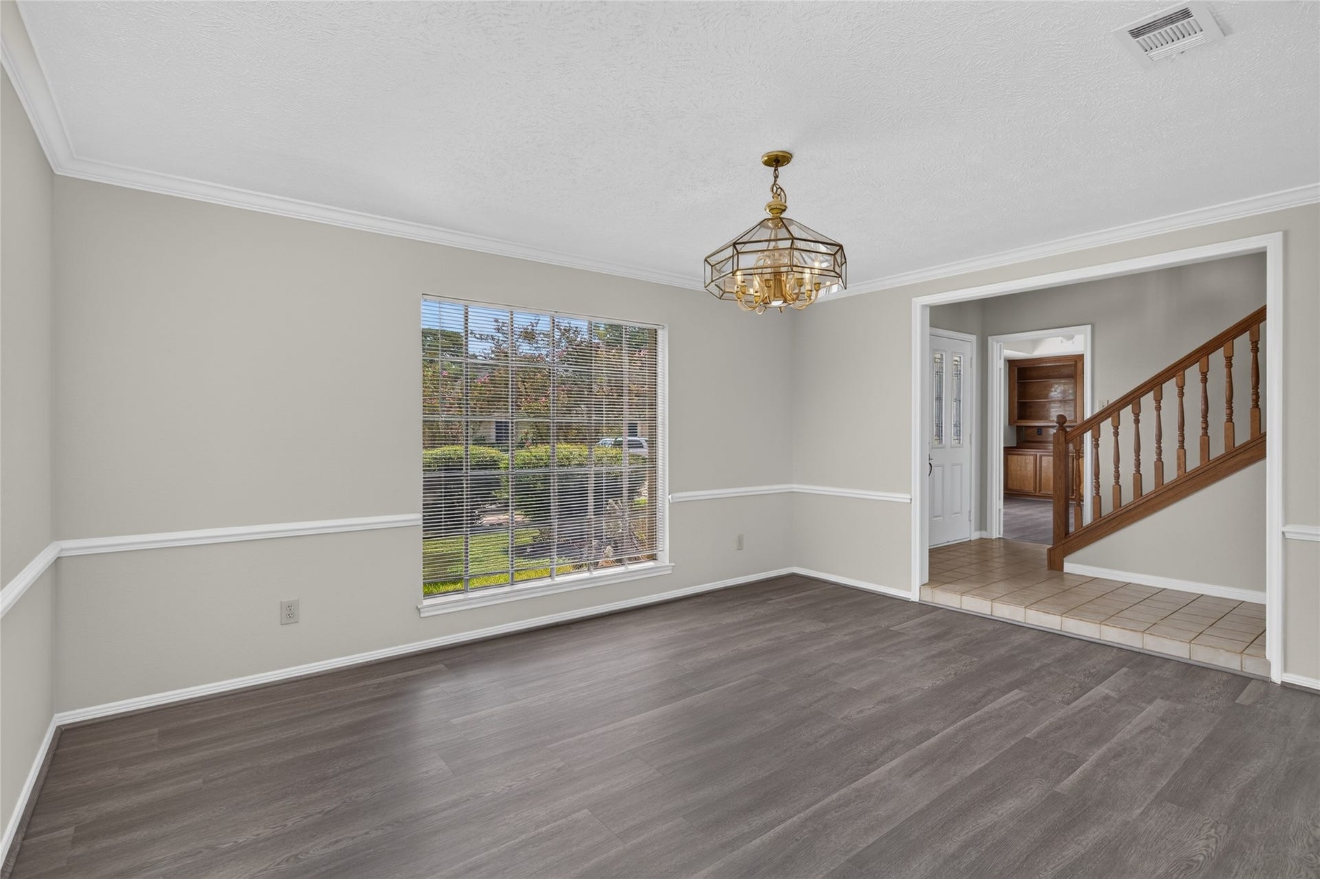 Natural light, crown molding, and a beautiful chandelier give this room an elegant foundation for everyday living, entertaining, or creating a comfortable gathering space of your own.