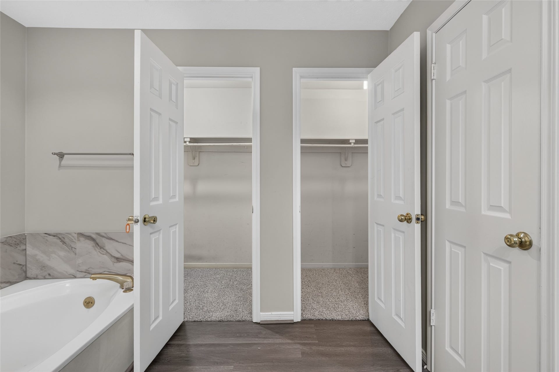 A generous soaking tub, marble accents, and dual closets provide both comfort and practical storage, giving the primary suite a sense of everyday luxury.
