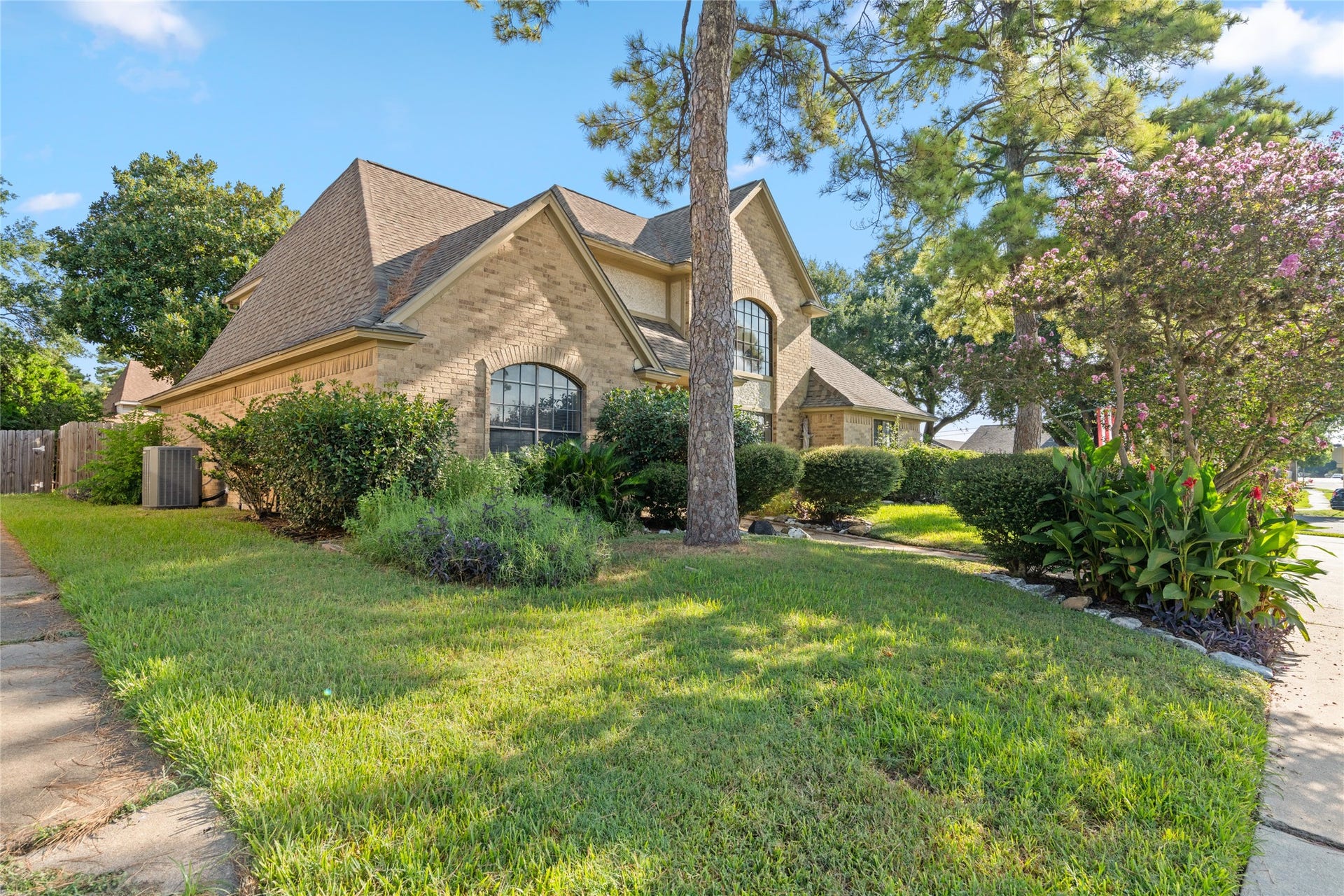 The sloped roofline, mature landscaping, and generous lawn come together beautifully, offering classic architectural character and inviting curb appeal.