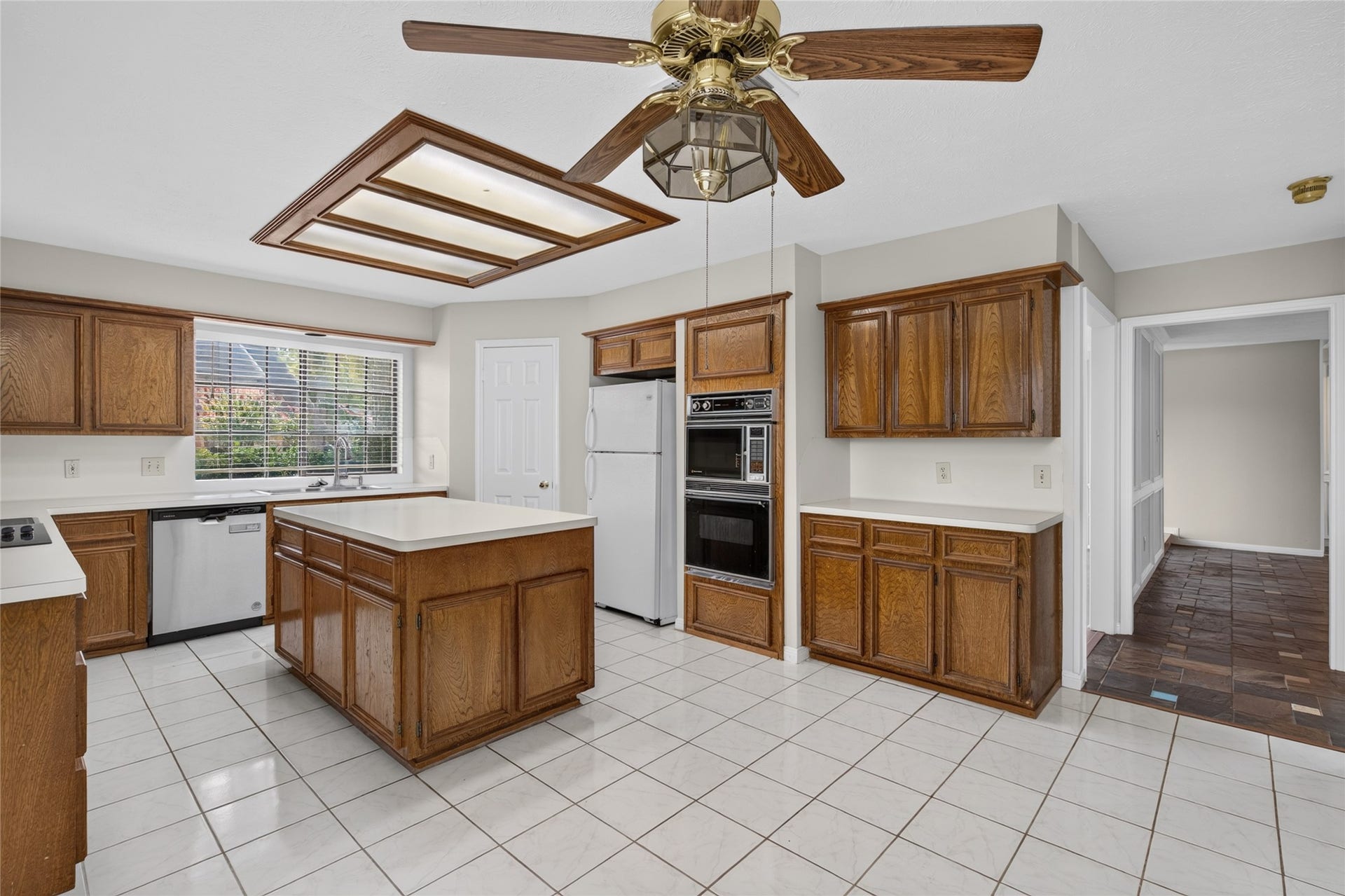 Classic wood cabinetry, a central island, and abundant natural light create a welcoming kitchen with the space to prepare meals, gather, and make this room the heart of the home.