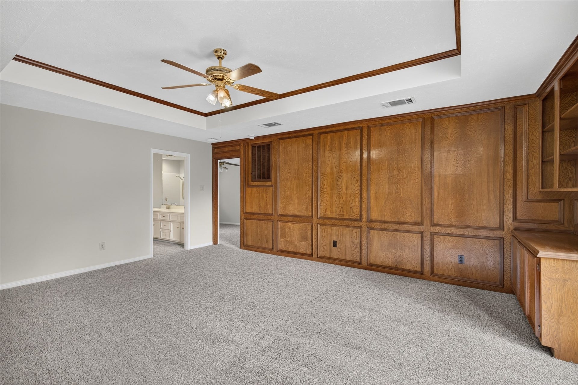 Built-in shelving, wood paneling, and a tray ceiling add character and functionality, creating a flexible space that can evolve with the way you live.