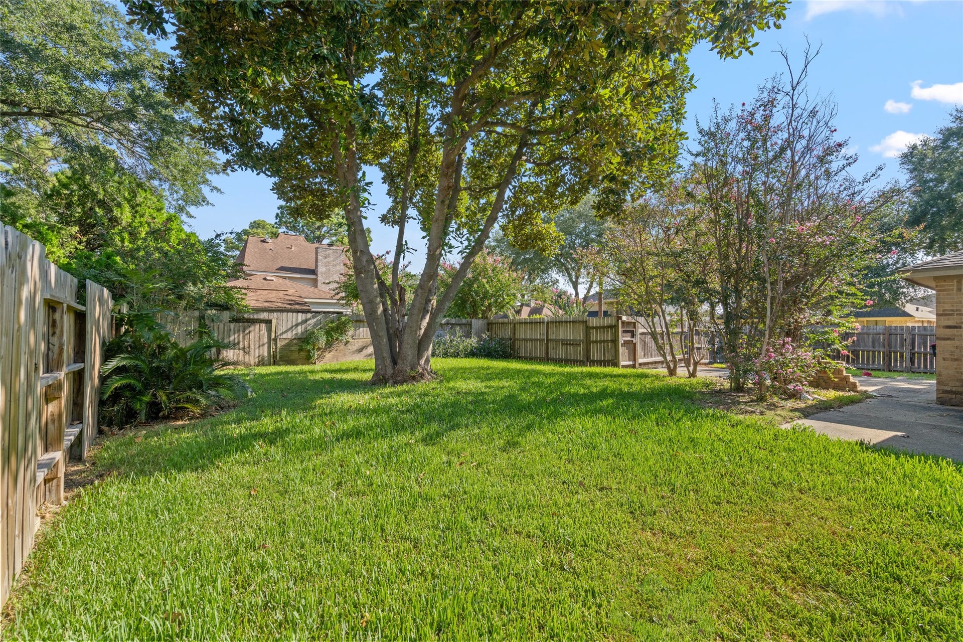 The spacious green lawn and mature trees provide a peaceful outdoor extension of the home, offering buyers a blank canvas for creating their own backyard lifestyle.