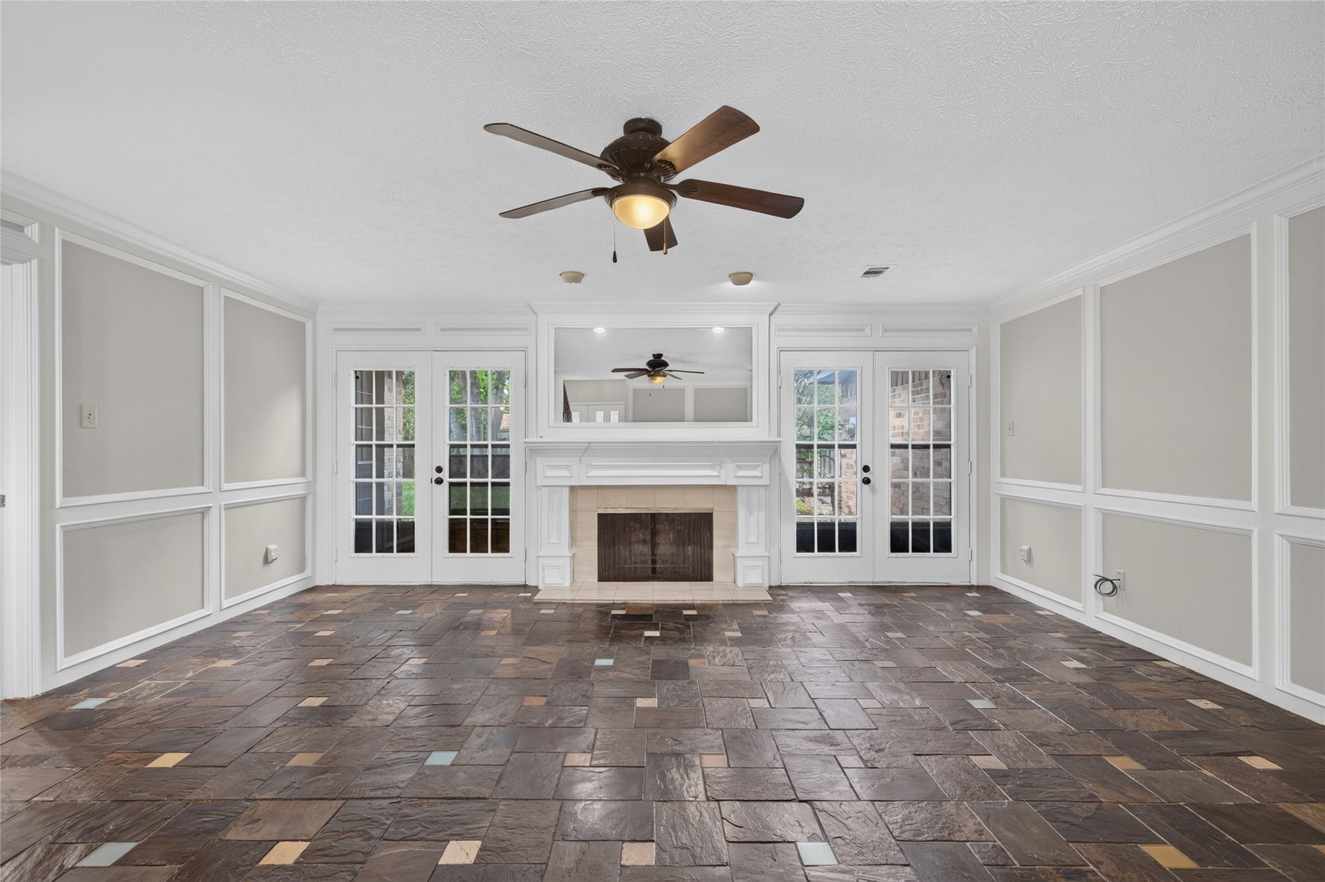 Double French doors flank the fireplace and bring the outdoors into view, while the open floor area provides plenty of flexibility for creating your ideal living arrangement.
