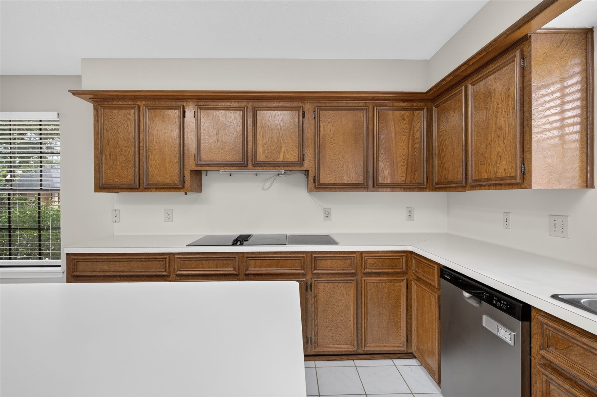 Sleek countertops, stainless-steel appliances, and abundant wood cabinetry provide a functional kitchen layout with generous storage and room to personalize the space to your taste.