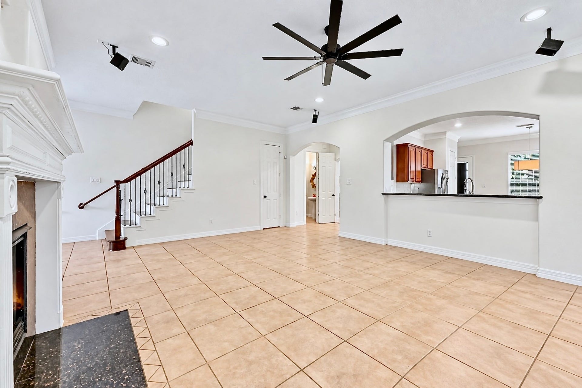 Spacious living area with soaring ceiling, open layout, and a graceful staircase. Virtually unstaged to highlight the rooms size and versatility