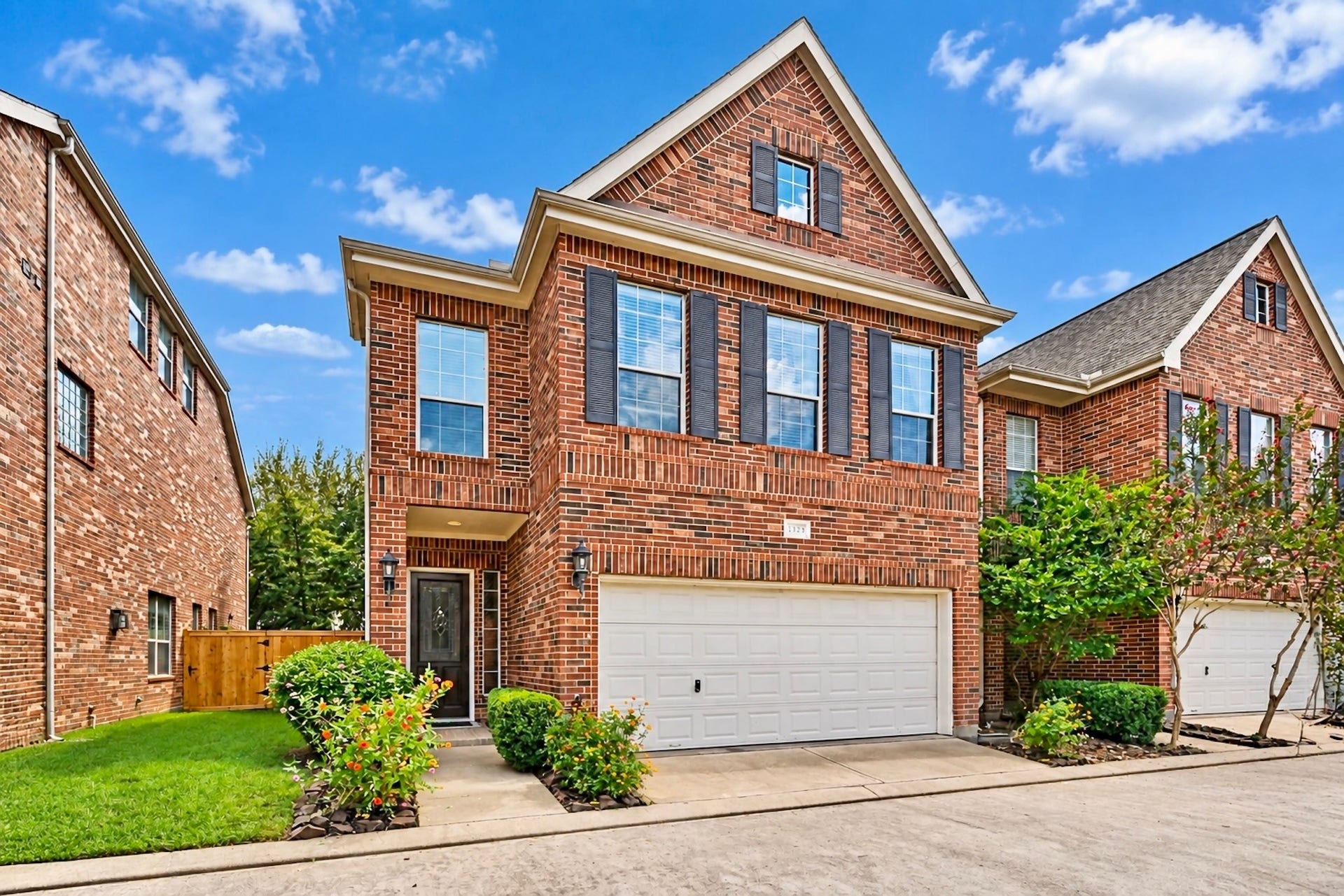 Elegant two-story brick residence with an attached two-car garage and welcoming front entry. Virtually enhanced photo.