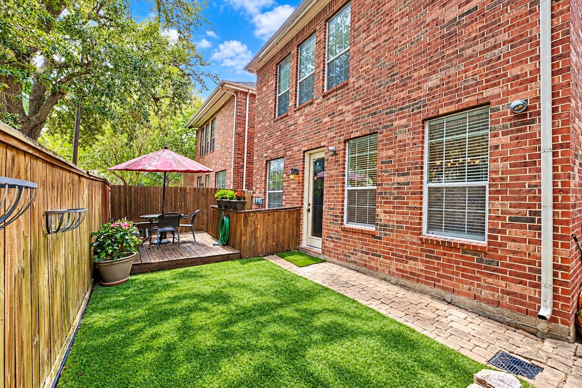 Low-maintenance backyard with artificial turf and patio, creating an easy-care outdoor space for relaxing or entertaining.