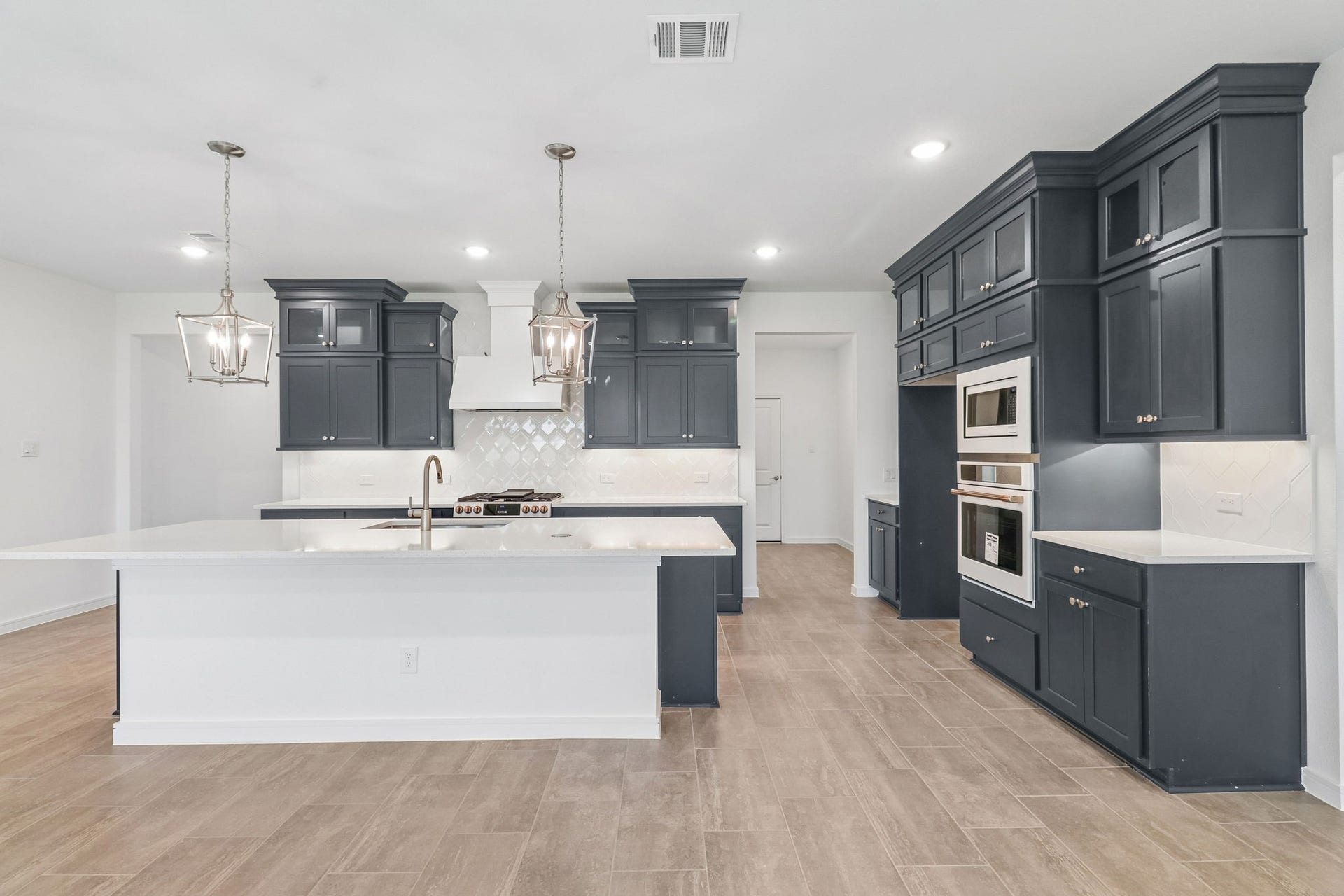 11822 Old Fashion Circle, Mont Belvieu, TX 77535 Upgraded kitchen with built in appliances, custom lighting, and intentional cabinetry.