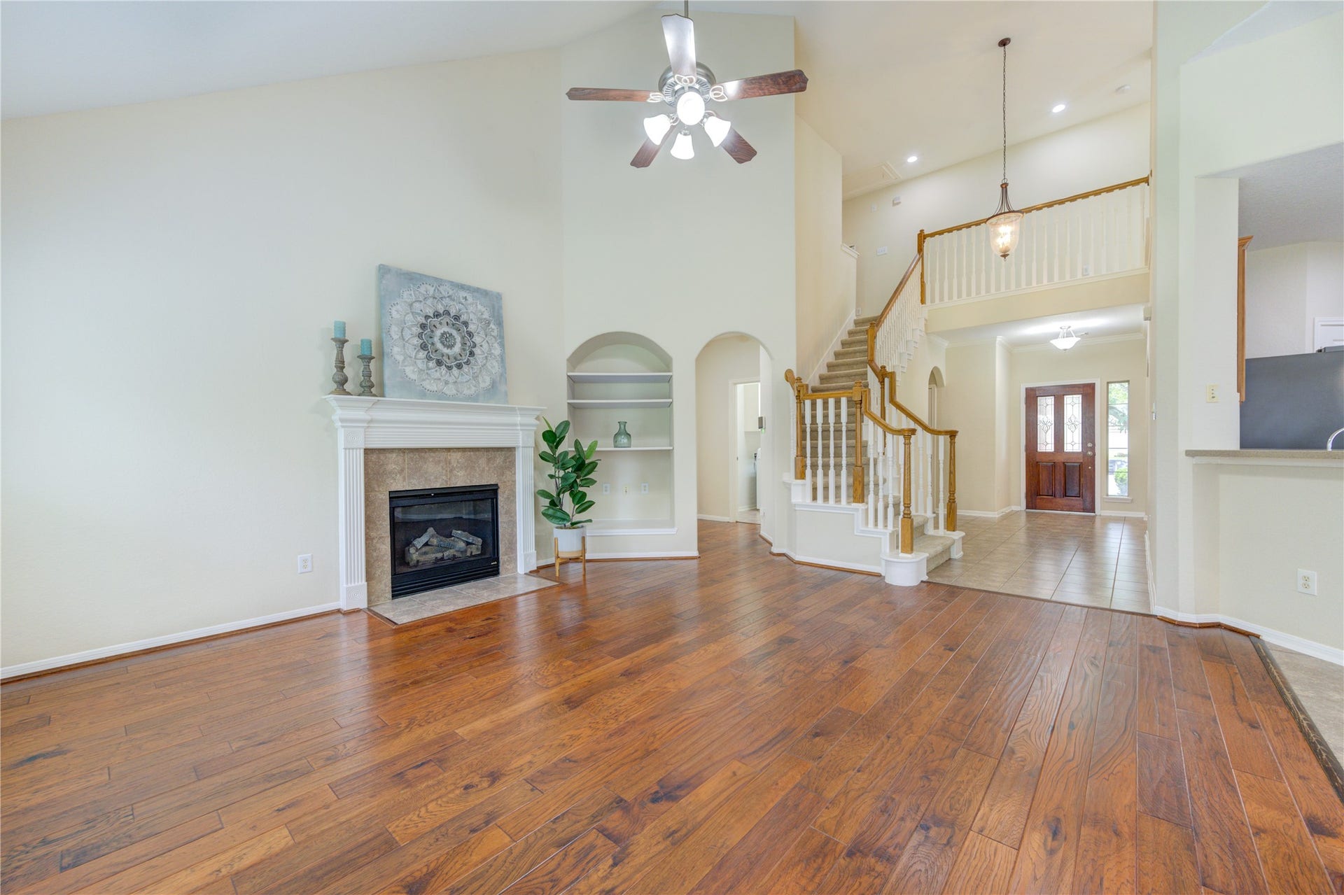 7811 Ravens Point Drive, Richmond, TX 77406 Stunning open-concept living area with dramatic two-story ceilings and an elegant staircase that makes a beautiful first impression.