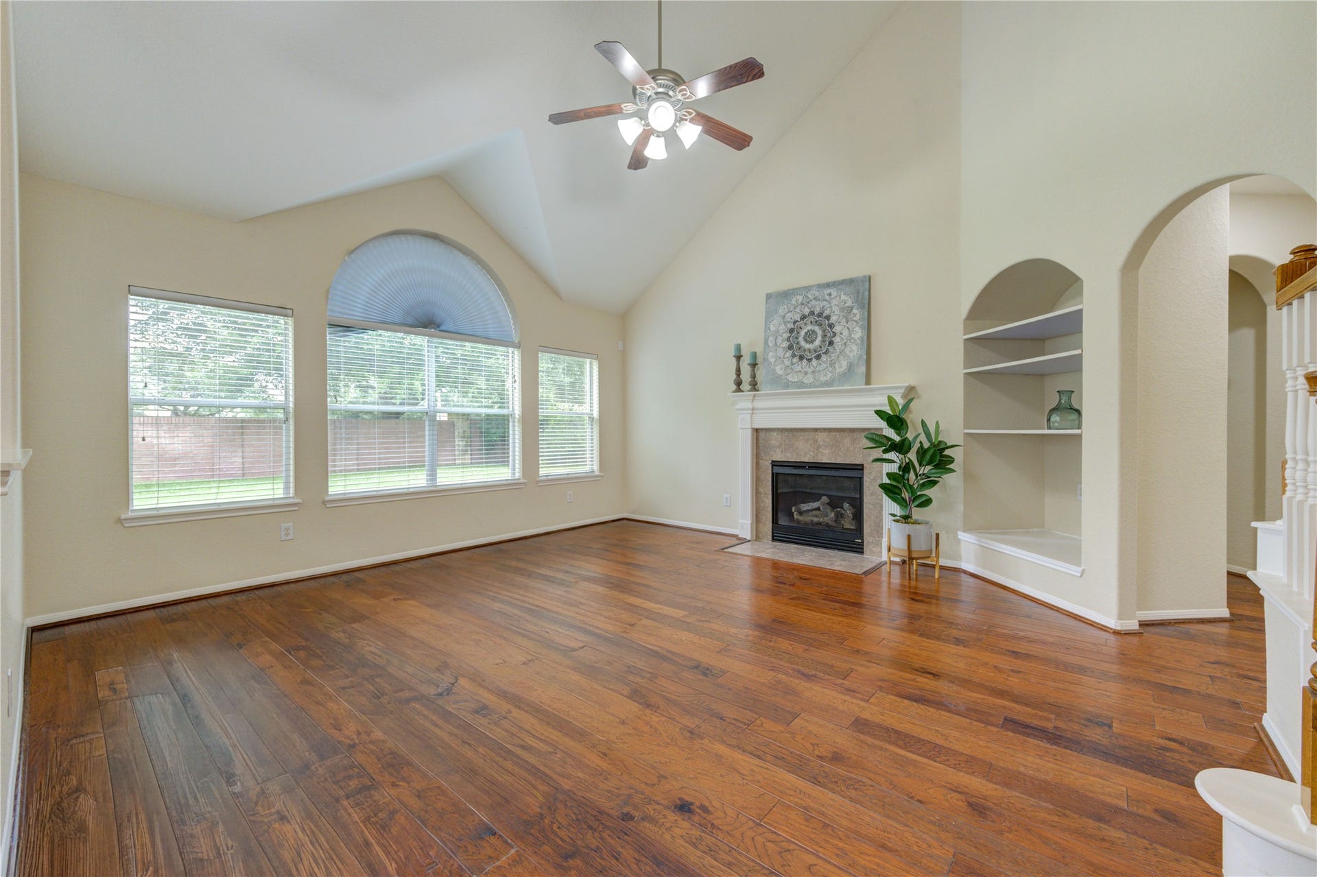 7811 Ravens Point Drive, Richmond, TX 77406 Bright and inviting living room with rich wood flooring, abundant natural light, and a cozy fireplace.