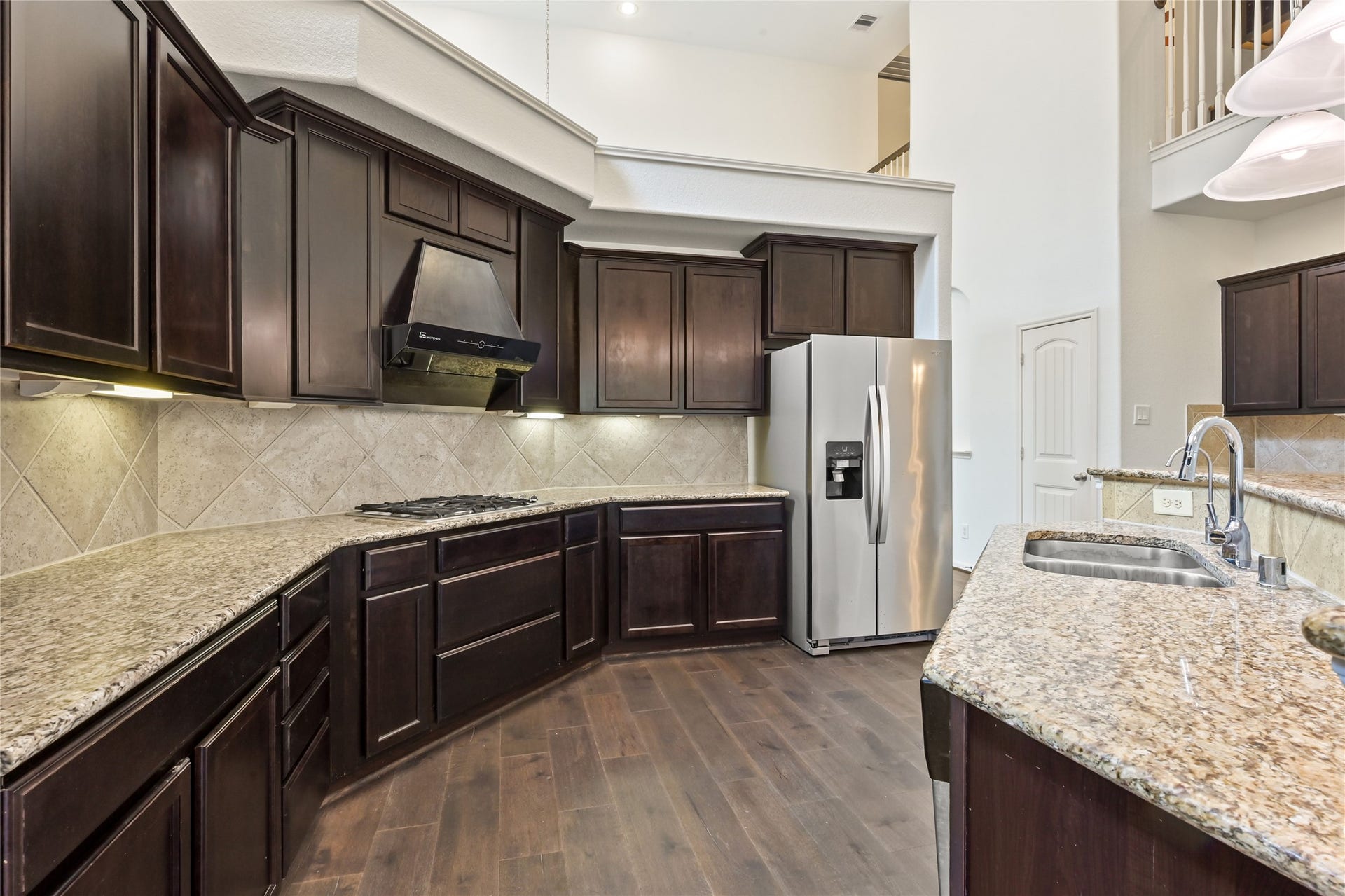 Kitchen offers extensive counter space, rich cabinetry, and modern finishes.