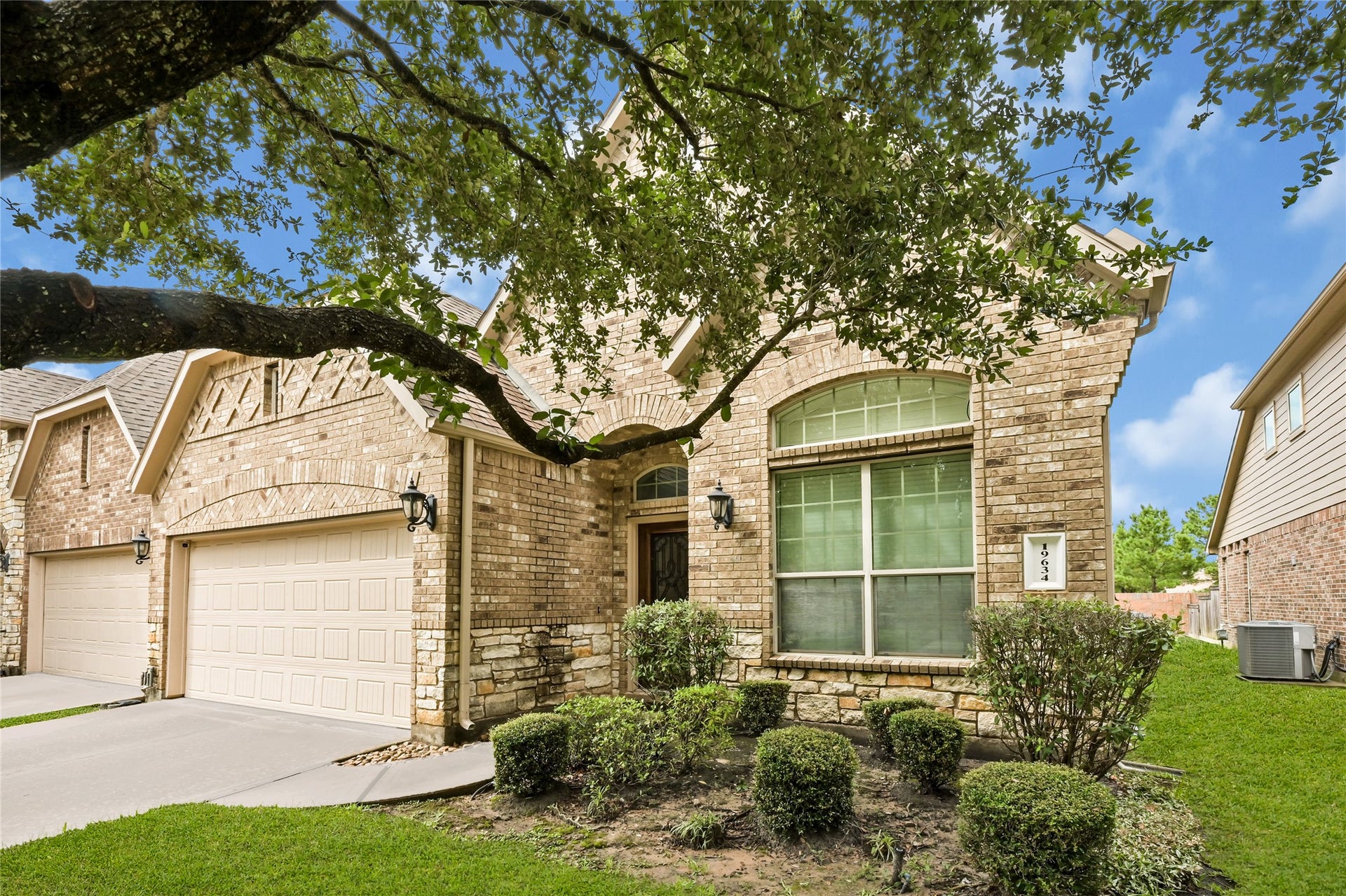 Beautiful brick and stone elevation with mature landscaping and covered entry.