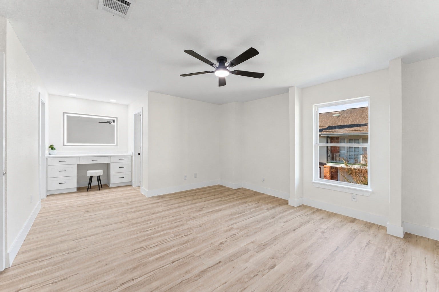 The primary bedroom has new flooring, a new window, and a new fan.