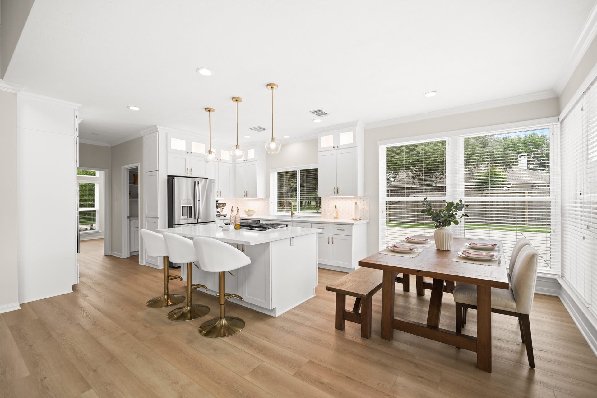 403 Trail Head Street, Friendswood, TX 77546 Open-concept living with a designer kitchen, oversized island, and sunlit dining area overlooking the backyard.