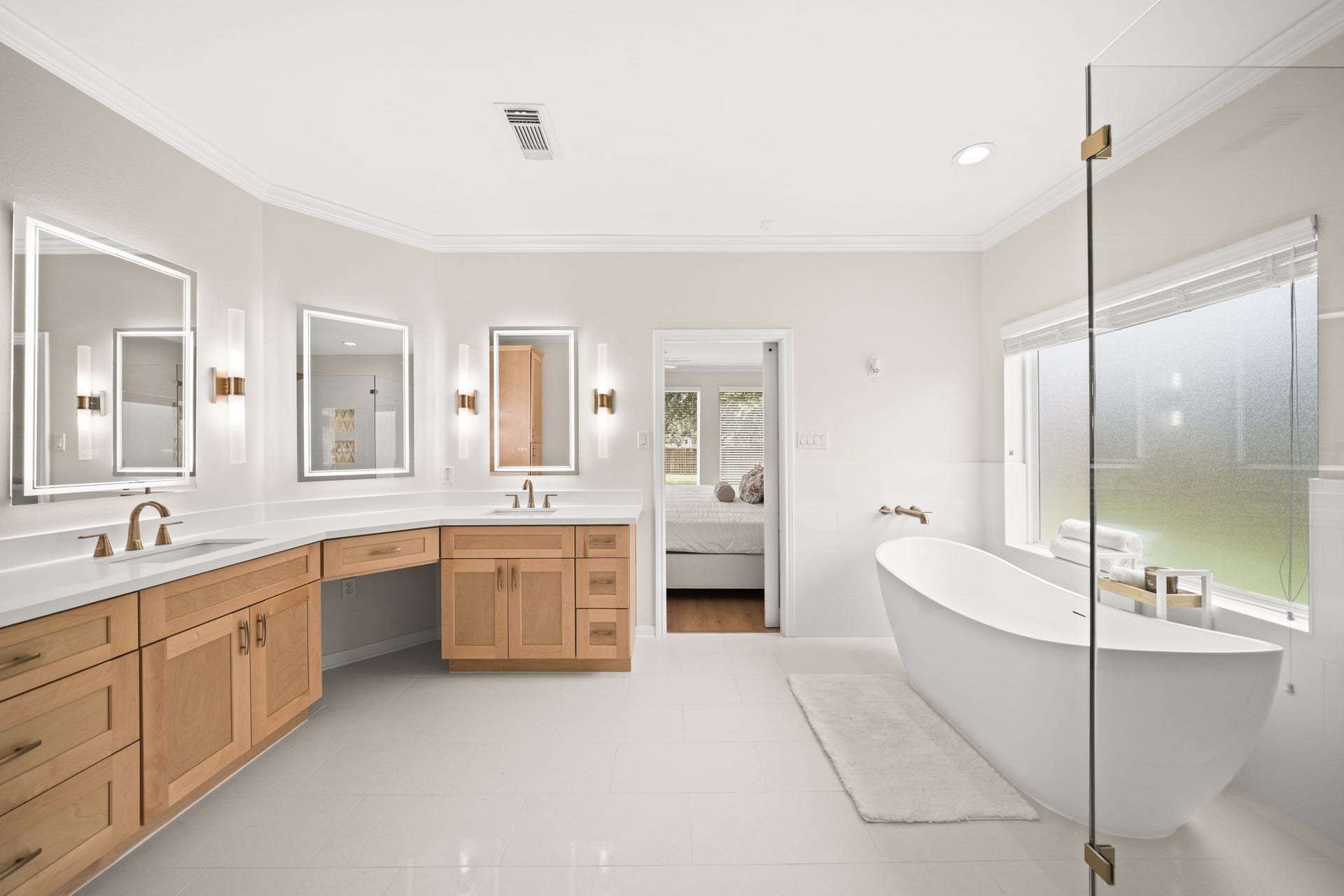 403 Trail Head Street, Friendswood, TX 77546 A true spa retreat, this expansive primary bath blends timeless elegance with modern luxury, featuring a freestanding soaking tub, oversized frameless shower, dual vanities, and abundant storage.