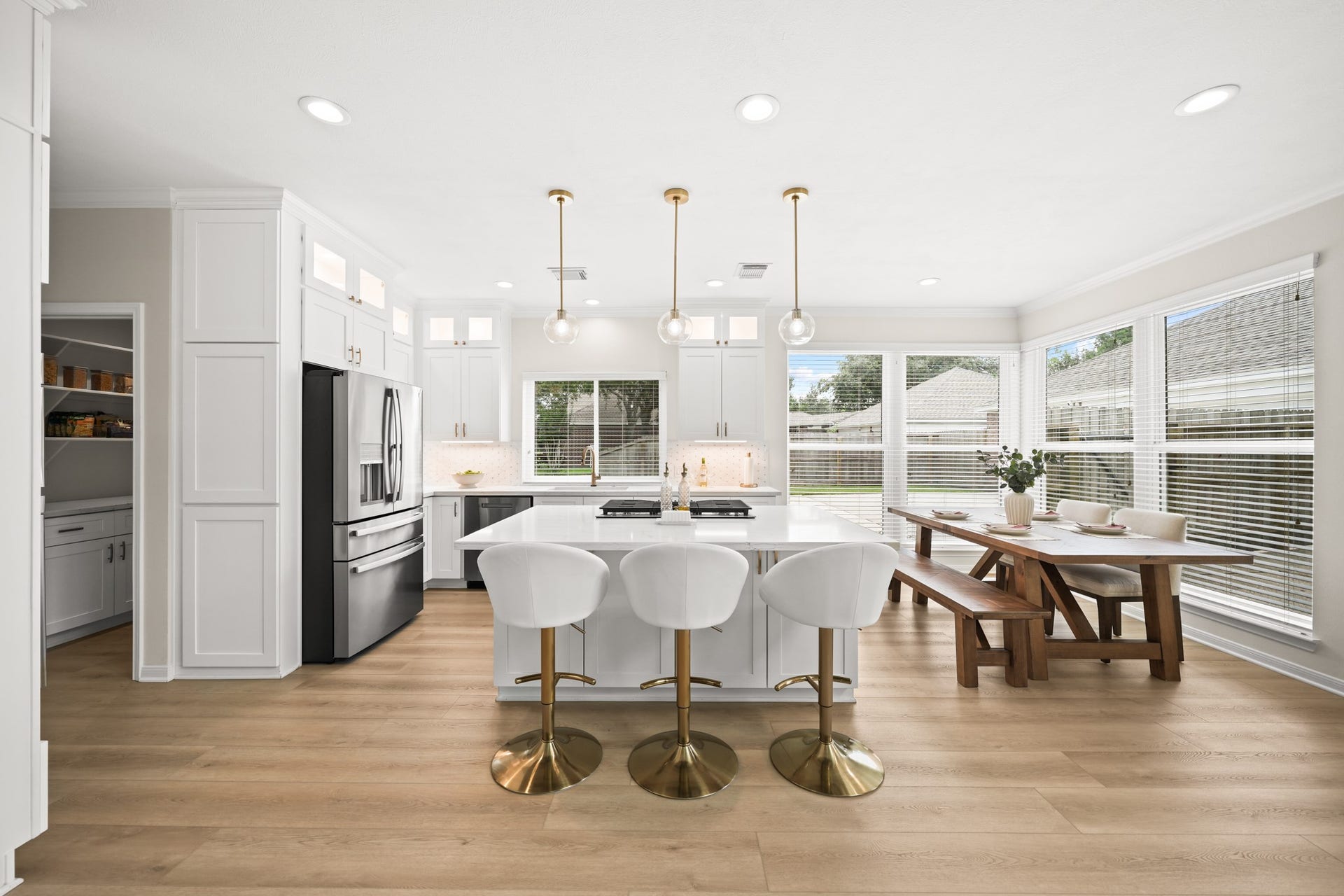 403 Trail Head Street, Friendswood, TX 77546 A showstopping open-concept kitchen where timeless design meets modern functionality, featuring a statement island, designer fixtures, and a wall of windows.