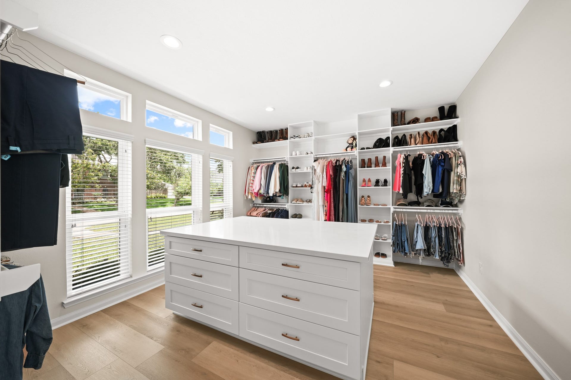 403 Trail Head Street, Friendswood, TX 77546 A true luxury amenity, this custom-designed primary closet showcases boutique-style organization, extensive built-ins, and a substantial center island with generous drawer storagecreating a dressing space as beautiful as it is functional.