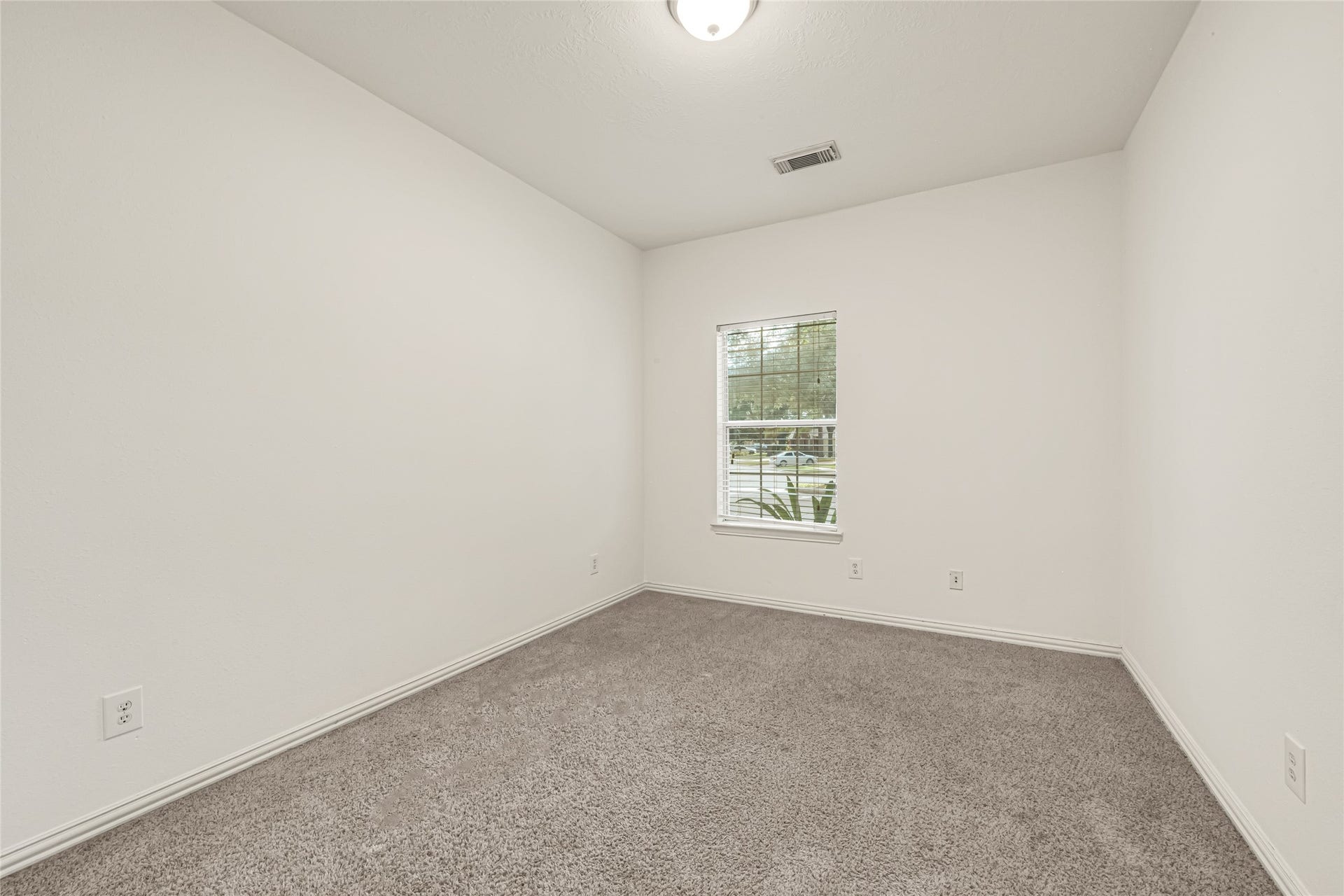 7102 Hollow Field Lane, Cypress, TX 77433 Cozy bedroom featuring plush carpeting, crisp neutral paint, and a large window framing pleasant neighborhood viewsperfectly suited for a guest room or secondary suite.