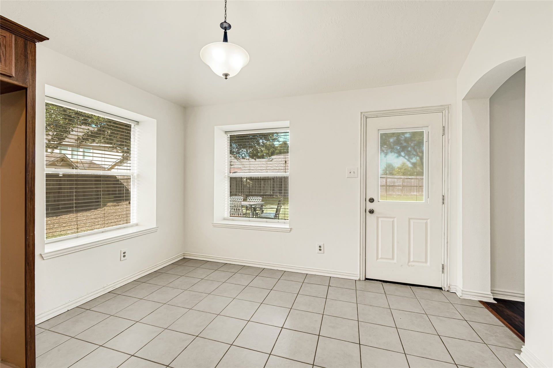 7102 Hollow Field Lane, Cypress, TX 77433 Bright breakfast nook area offering direct backyard access via a classic paneled glass patio door, paired with multiple windows for a light-filled dining experience.