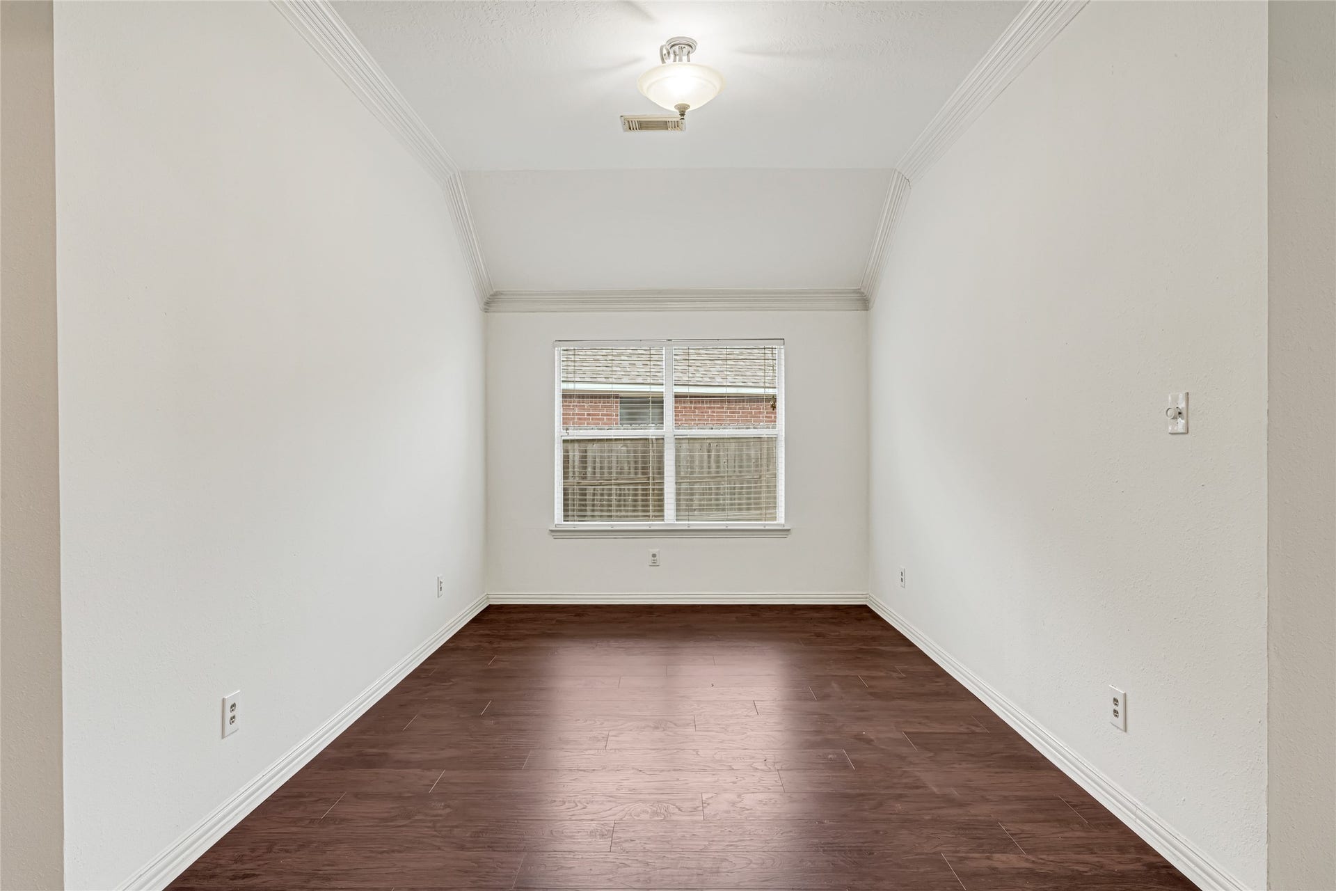7102 Hollow Field Lane, Cypress, TX 77433 Versatile front room with rich wood-look flooring and a large window, perfectly configured for a formal dining room, quiet sitting area, or home office.