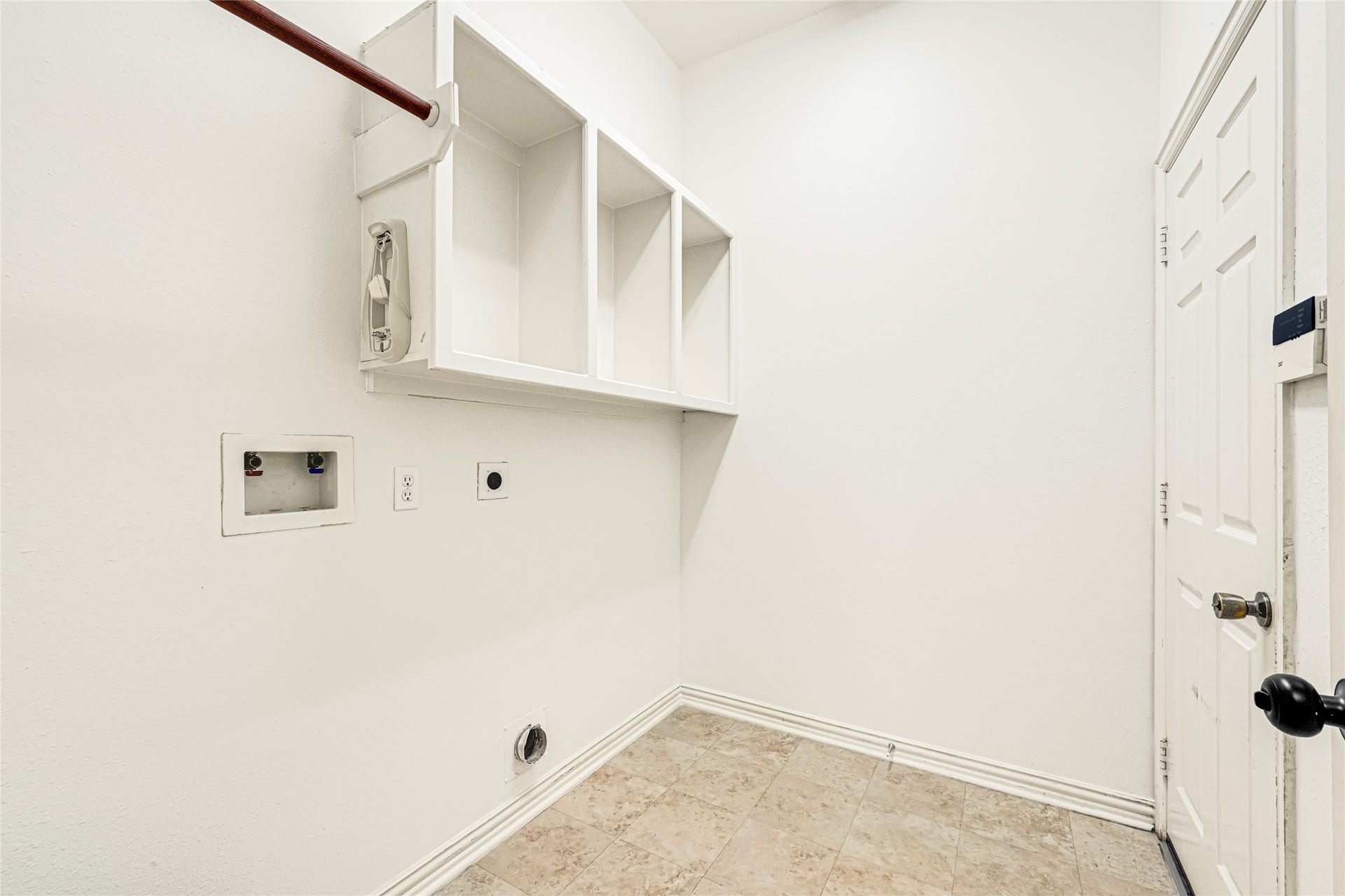 7102 Hollow Field Lane, Cypress, TX 77433 Functional utility room complete with durable tile flooring, dedicated laundry hookups, a hanging rod, and convenient built-in upper storage cubbies.