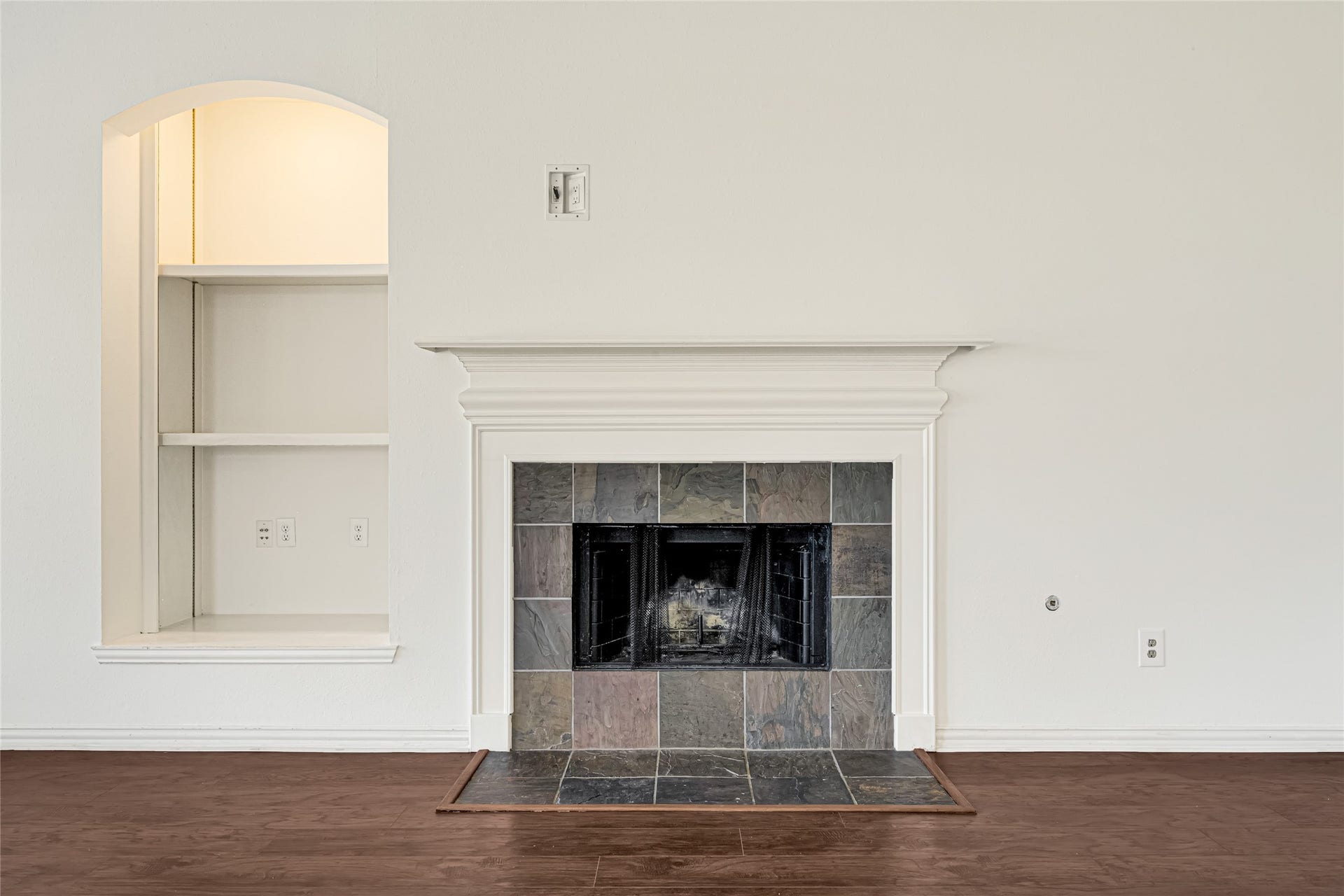 7102 Hollow Field Lane, Cypress, TX 77433 Close-up of the focal-point fireplace featuring a classic white mantel, custom stone surround, and an adjacent built-in media alcove with recessed lighting.