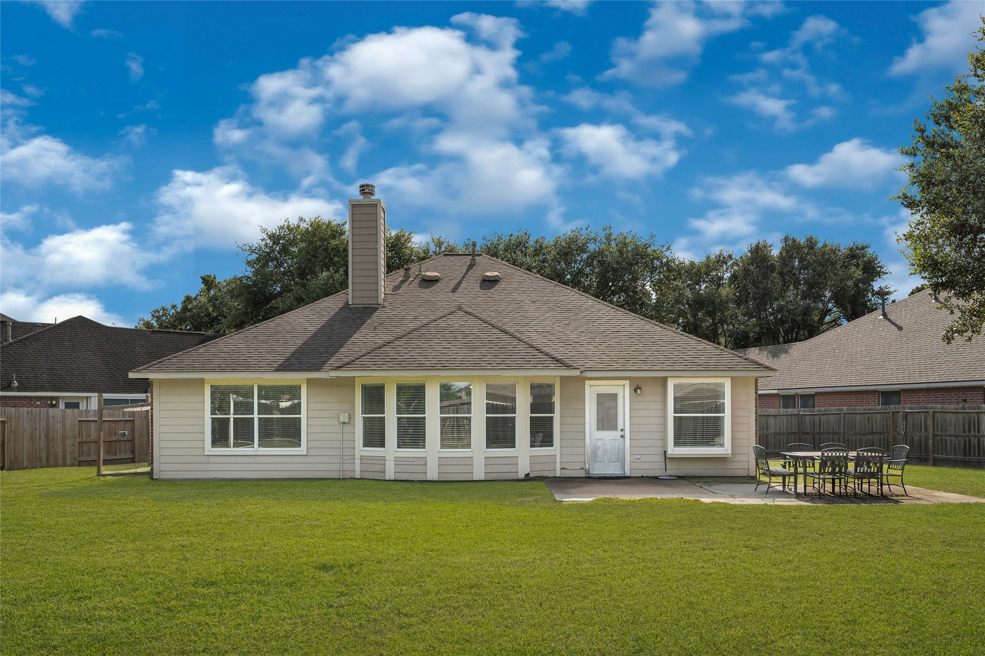 7102 Hollow Field Lane, Cypress, TX 77433 Expansive backyard featuring a concrete patio area, ideal for outdoor entertaining and dining, against a classic neutral siding exterior.