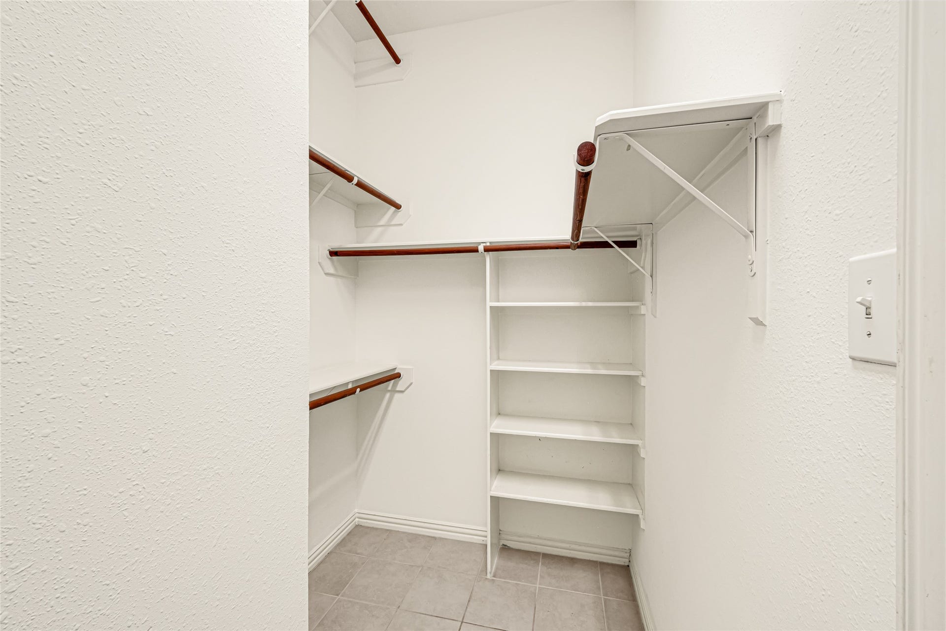 7102 Hollow Field Lane, Cypress, TX 77433 Expansive walk-in primary closet offering abundant storage space with built-in shelving units and multi-level hanging rods.