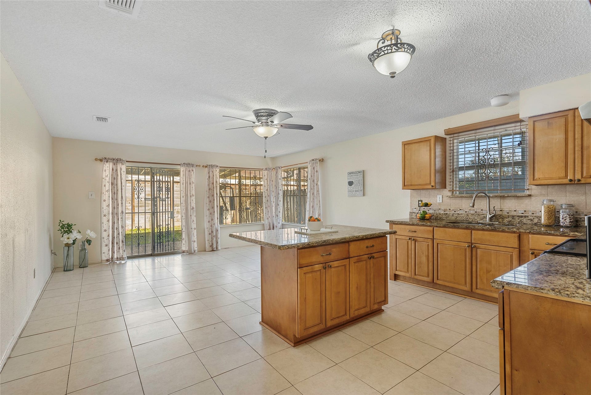 The kitchen is tucked away at the back of the home with direct access to the yard! There is also an additional living area, so you can watch your favorite shows as you cook!