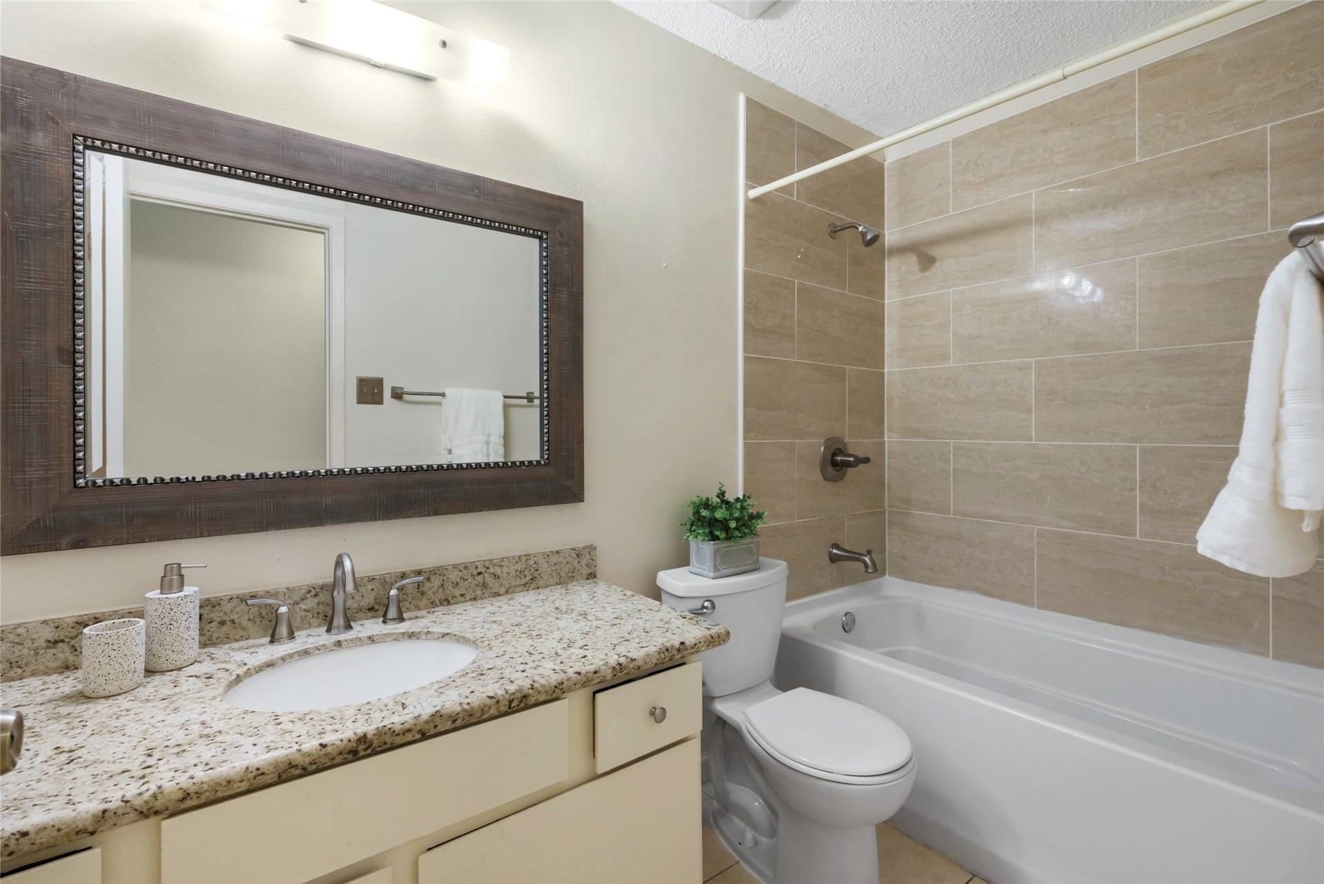 The hall bath has been modernized with an extended counter space, granite counters and tile surrounding the tub!