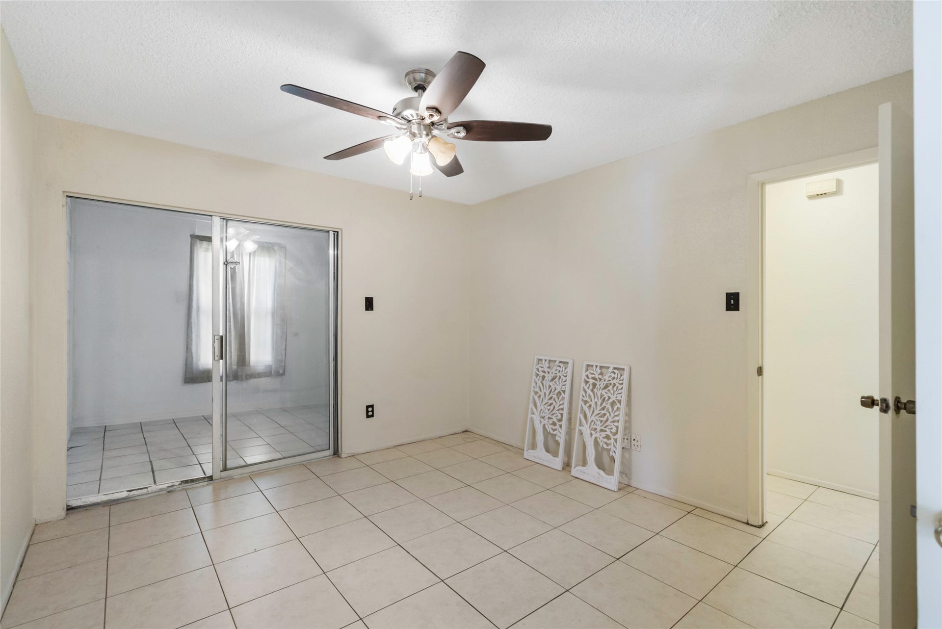 This secondary bedroom has an enclosed patio that can be used as a home office or flex space!