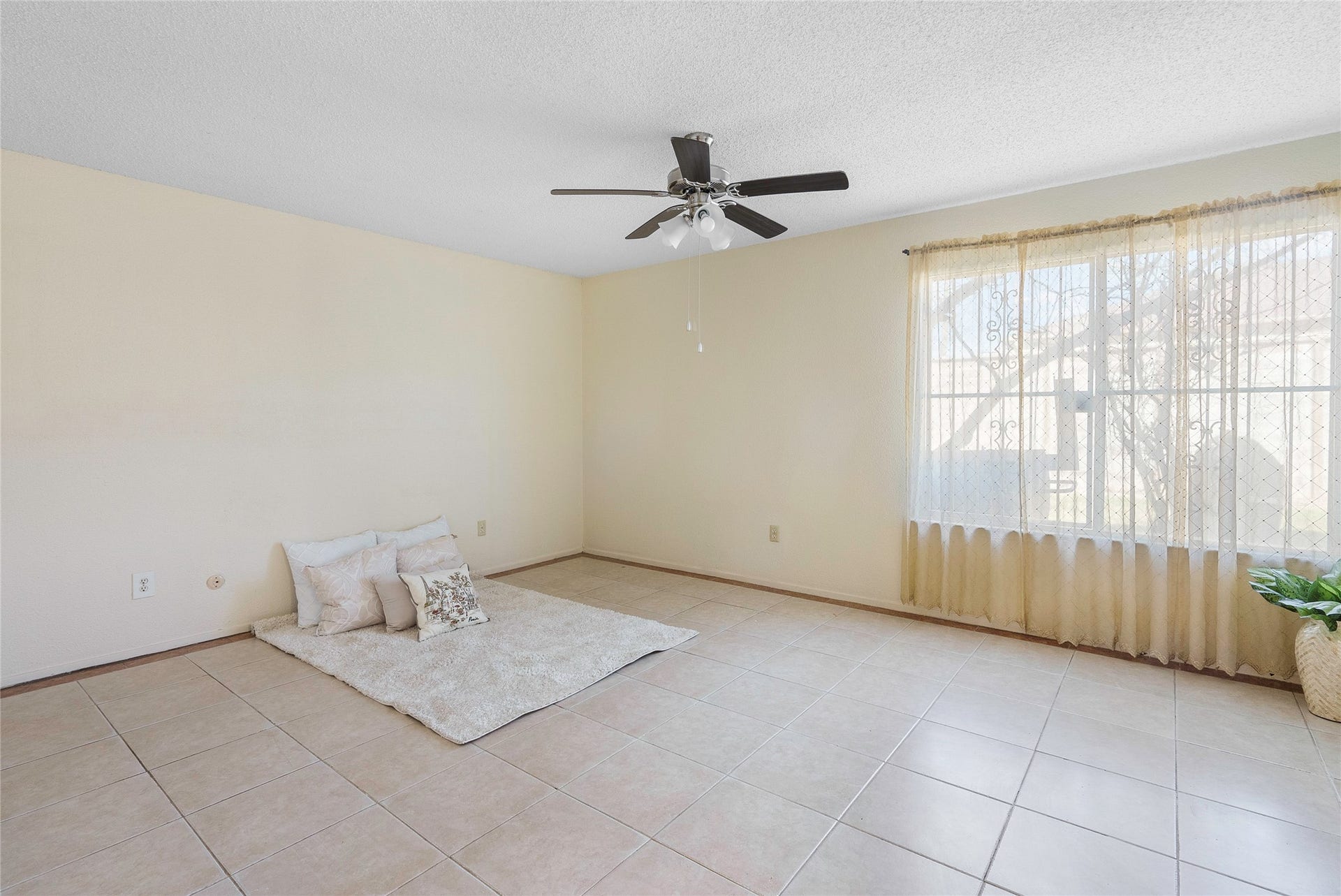 The primary bedroom has no carpet, bright window and ceiling fan!