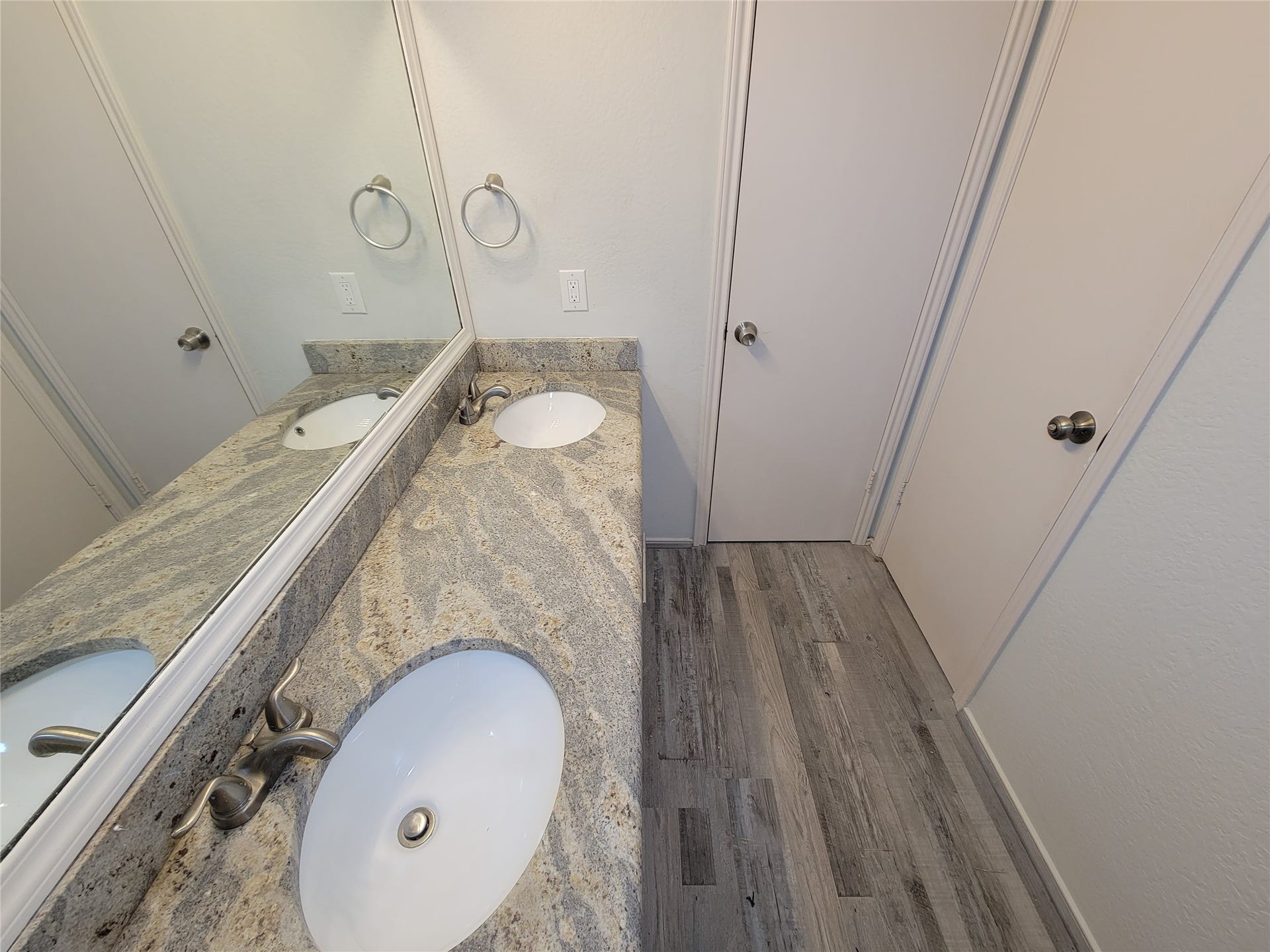 80 Fallenstone Drive, The Woodlands, TX 77381 Elegant bathroom featuring a dual-sink vanity with granite countertops and stylish fixtures, complemented by sleek flooring and ample mirror space.