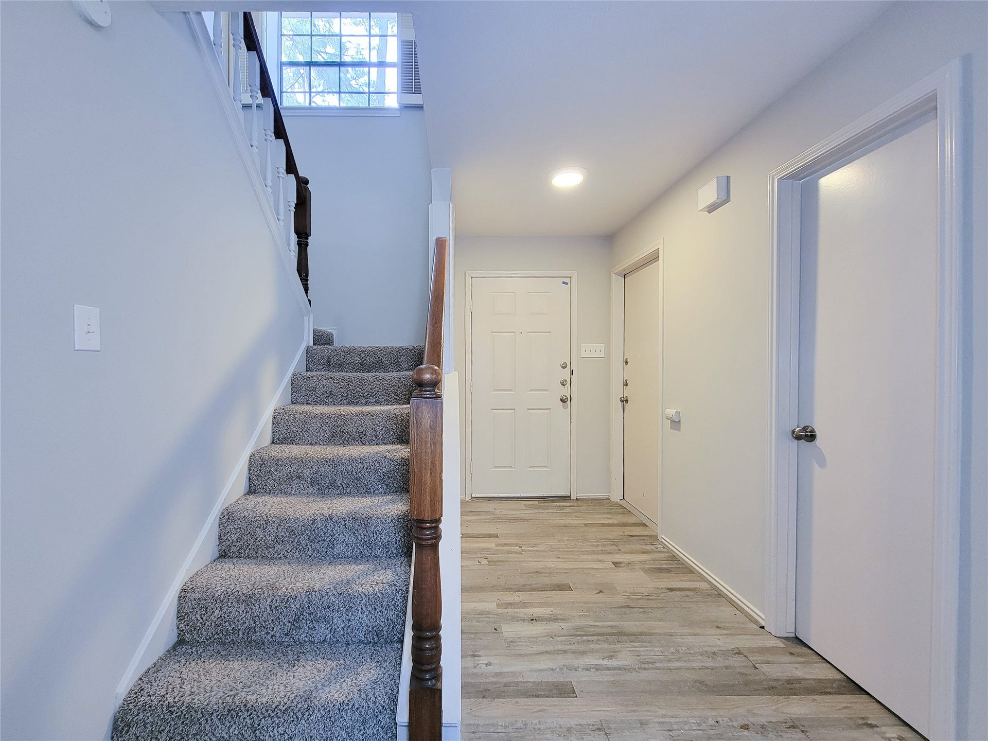 80 Fallenstone Drive, The Woodlands, TX 77381 Bright and welcoming entryway with modern flooring and a carpeted staircase leading to the upper level, complemented by neutral walls for a fresh, airy feel.