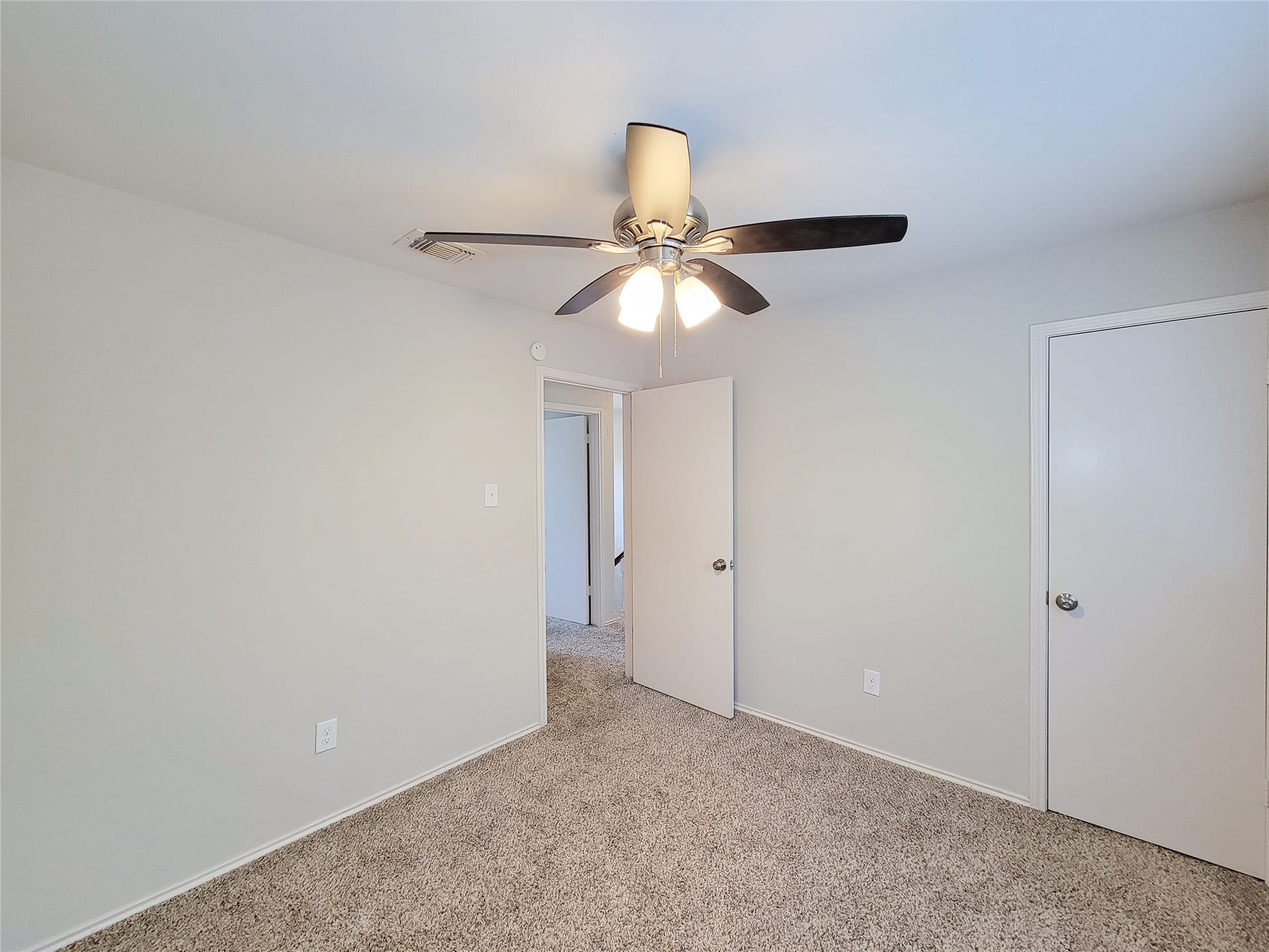 80 Fallenstone Drive, The Woodlands, TX 77381 Bright bedroom with soft carpet, neutral walls, and a ceiling fan for comfort.