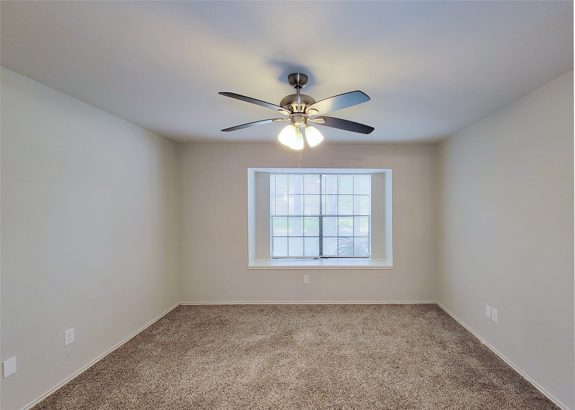 80 Fallenstone Drive, The Woodlands, TX 77381 Spacious bedroom featuring plush carpet, neutral walls, a ceiling fan with light, and a large window offering natural light.