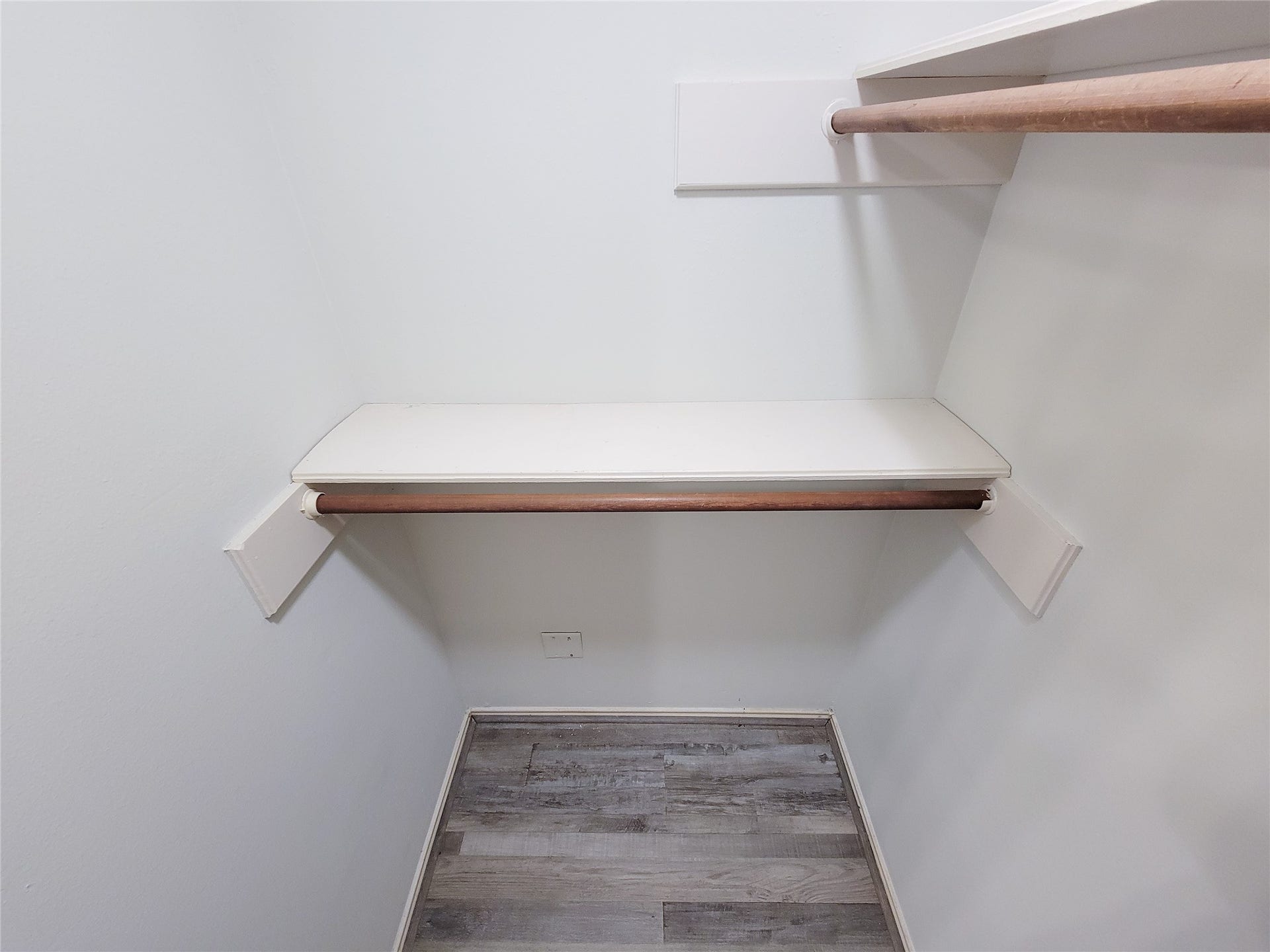 80 Fallenstone Drive, The Woodlands, TX 77381 Spacious walk-in closet featuring dual hanging rods and a convenient built-in shelf, complemented by sleek wood flooring.