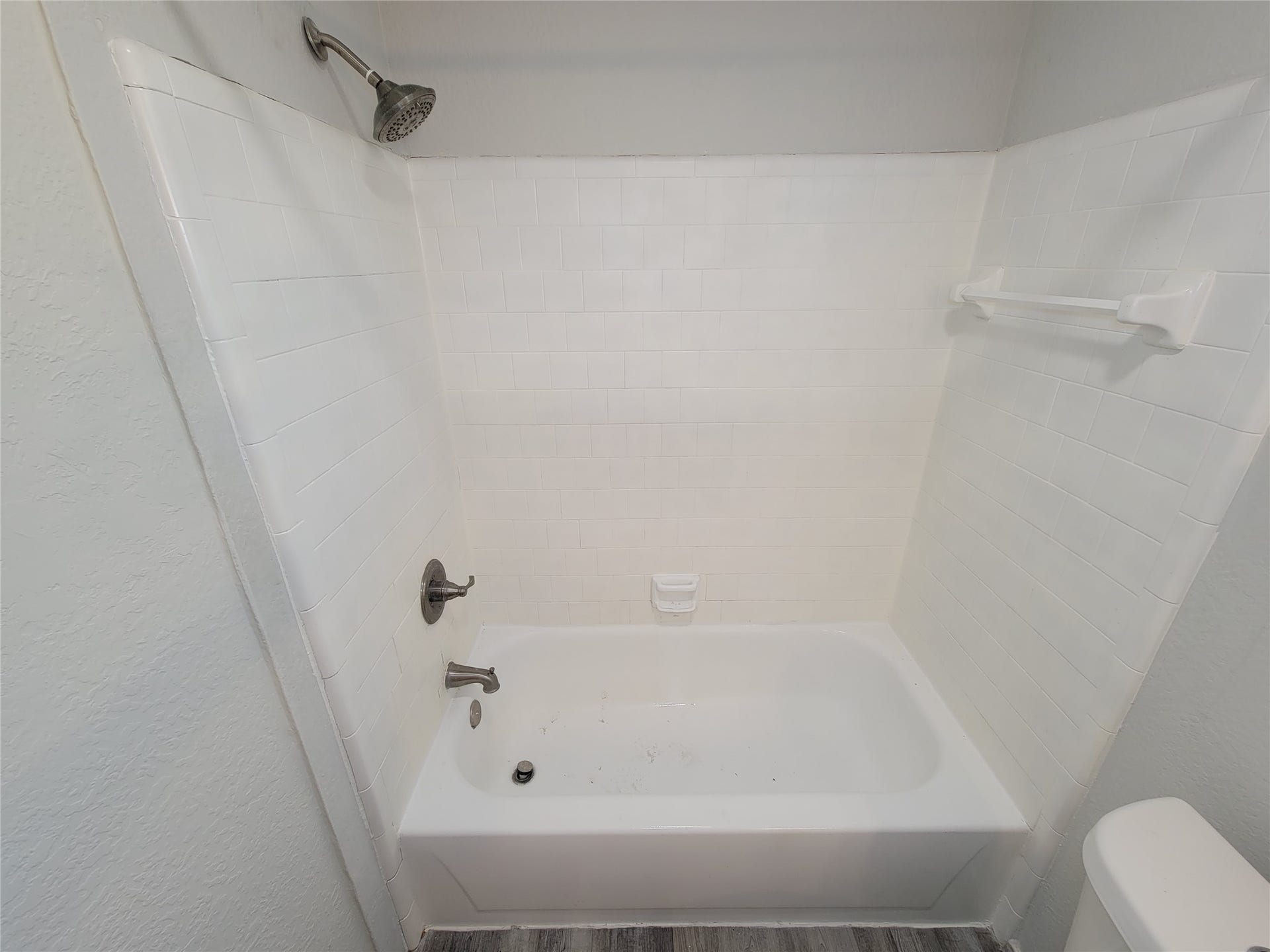 80 Fallenstone Drive, The Woodlands, TX 77381 Bright and clean bathroom featuring a classic white tiled shower and tub combo, complemented by modern fixtures and neutral tones.