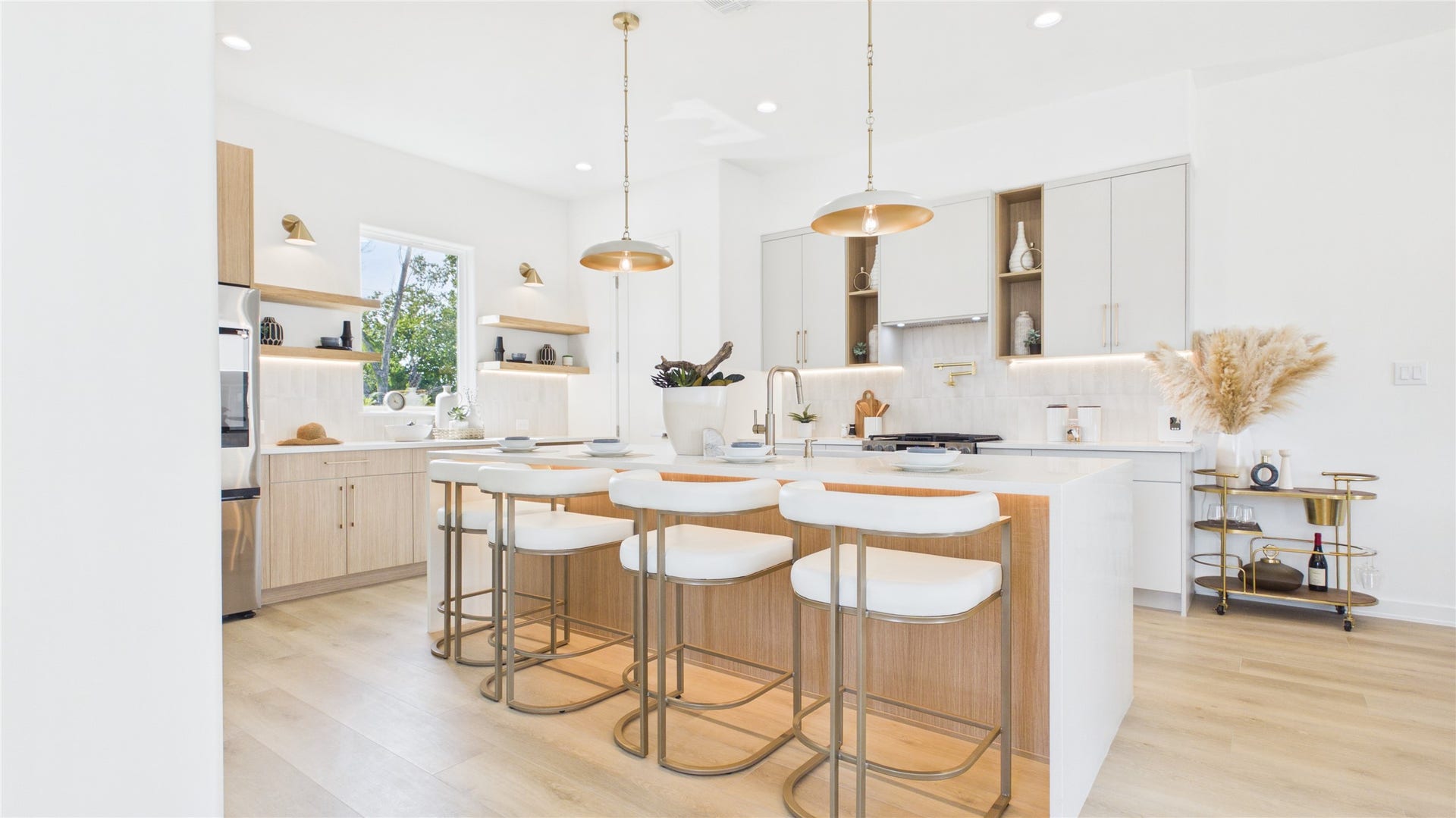 Modern kitchen featuring a spacious island with elegant bar seating, under island lighting, sleek cabinetry, and stylish pendant lighting, perfect for entertaining.