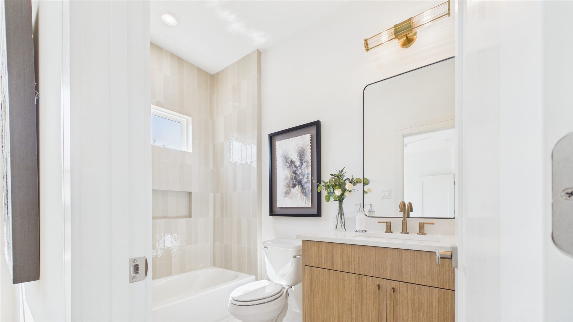 Secondary en suite bathroom featuring sleek fixtures, and stylish vanity, all complemented by natural light.